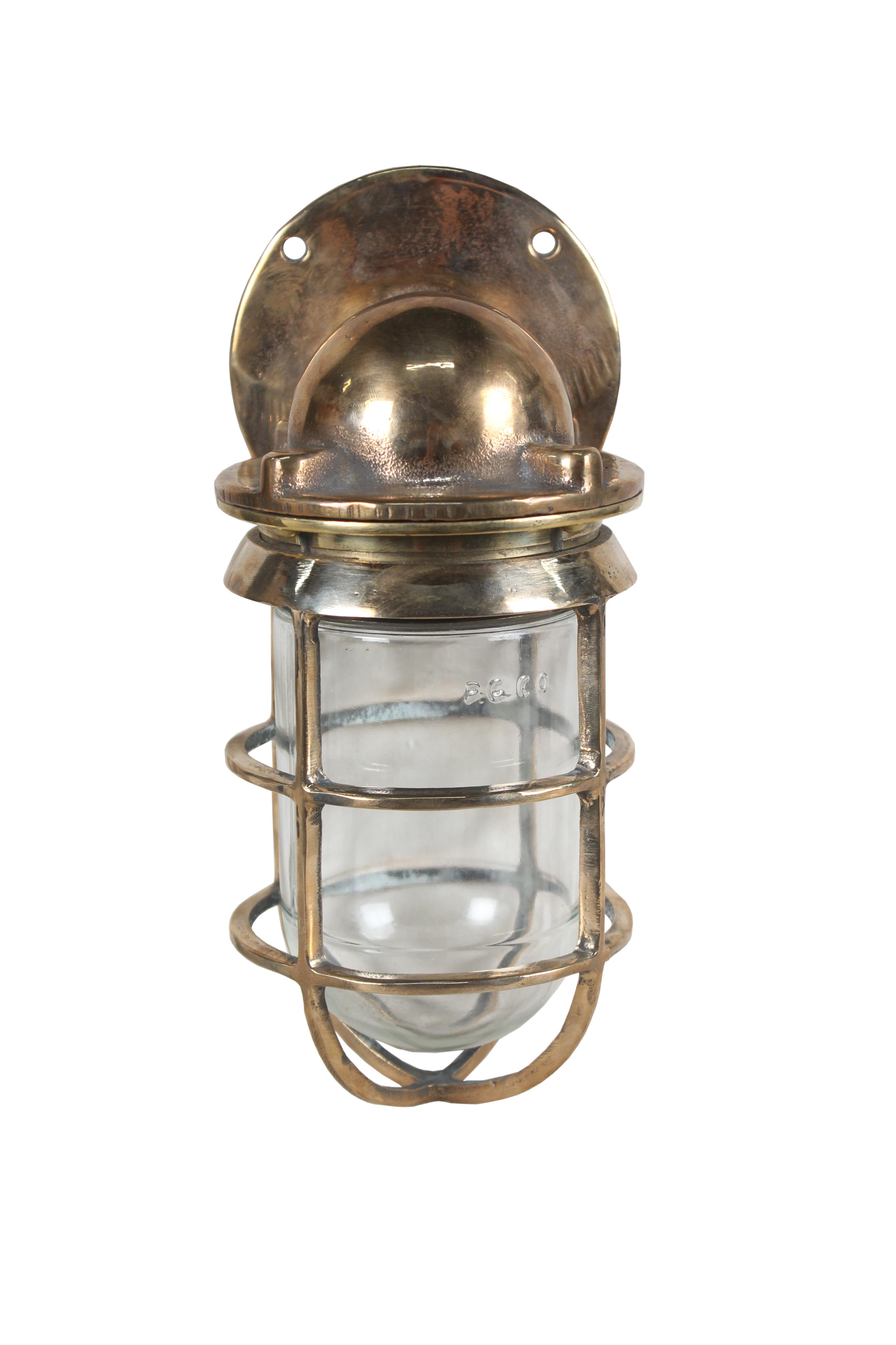 Pair of bronze ship's passageway sconce lights with bronze cage and glass shade. Both the cage and shade unscrew separately to gain access to the bulb. They take a standard base bulb and have been rewired. American, 1970s.