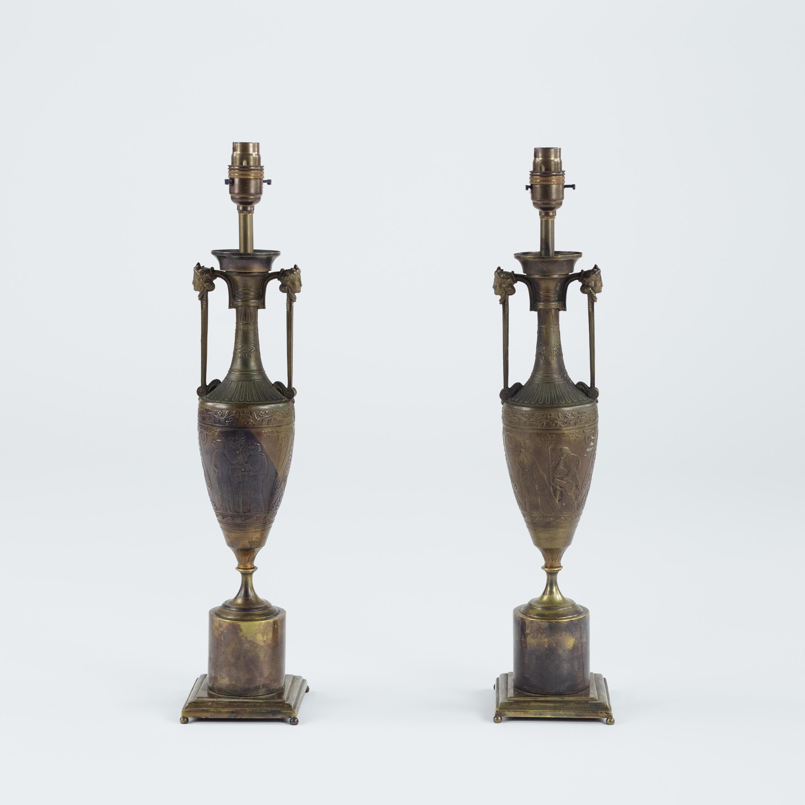 Paire de vases en bronze patiné du Grand Tour de Néo-Grec, montés en lampe, fondus par Ferdinand Barbedienne d'après un modèle d'Henry Cahieux.

Chaque vase est doté d'une anse en forme de tête d'hermès encadrant un col mince et allongé au-dessus