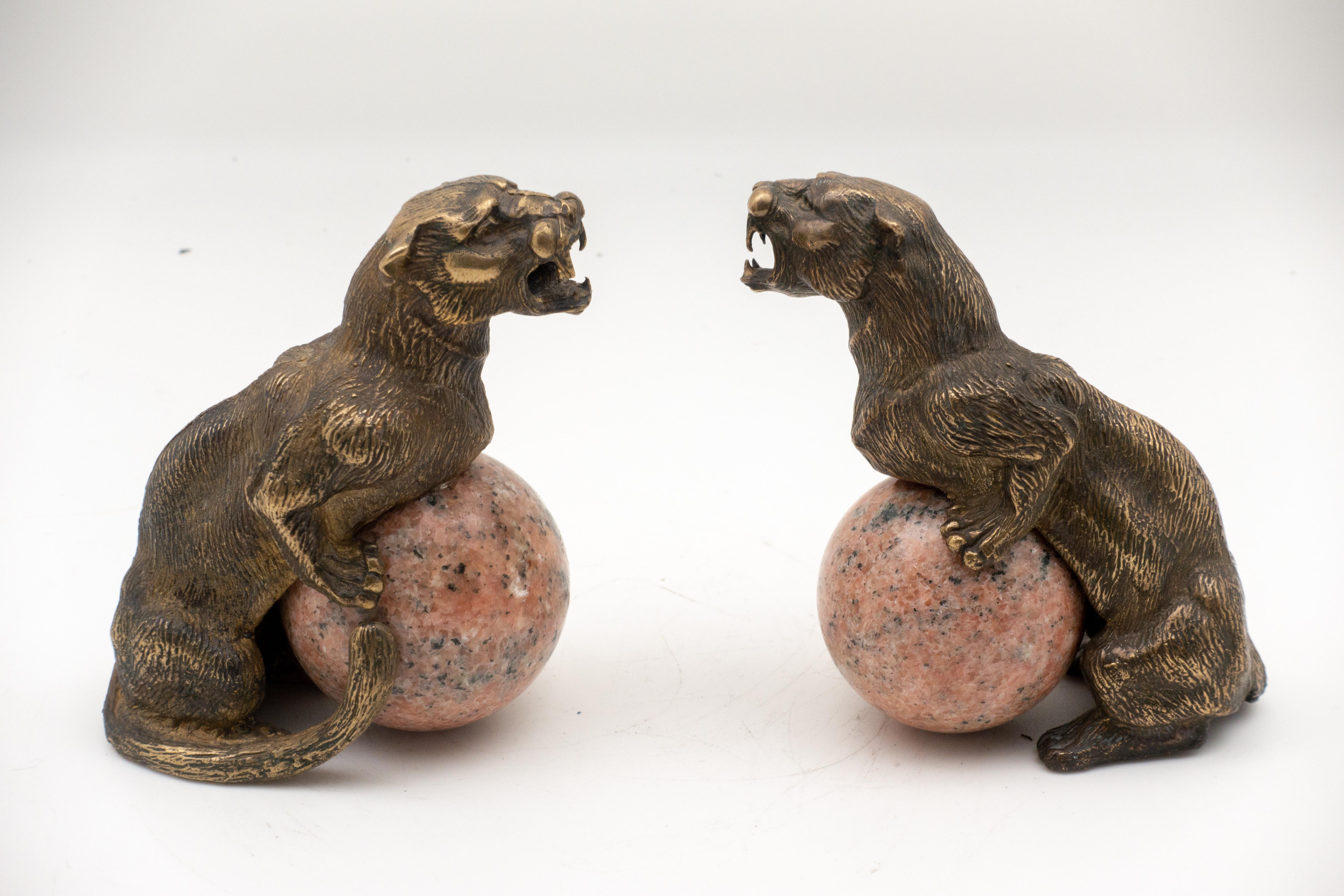 Pair of bronze panthers fitted to hold marble spheres (included); depicted with forelegs perched on sphere, roaring. Antique pair from France, 19th century.