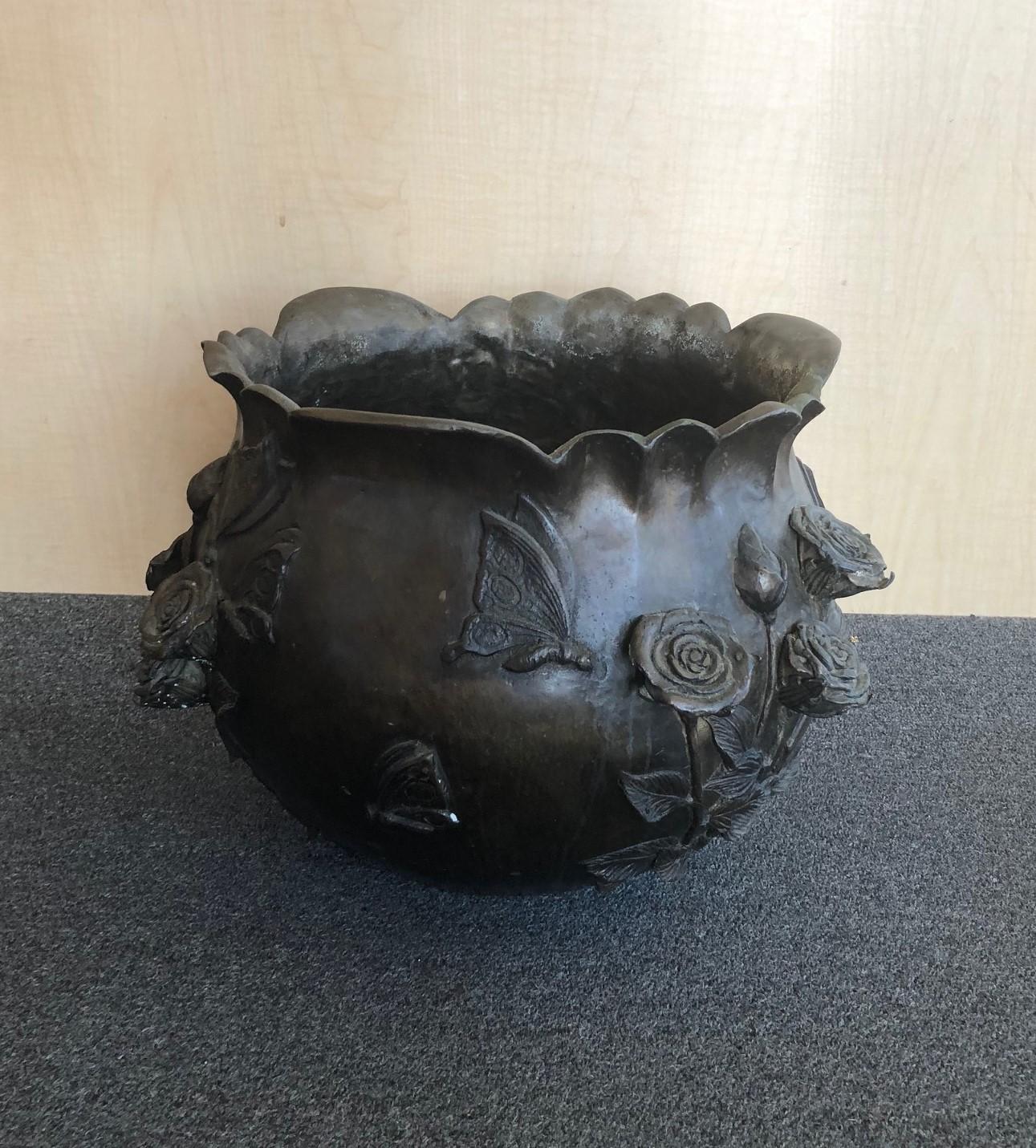 A very nice pair of large bronze planters or jardinières with a bas relief floral motif, circa 1950s. The planters are very heavy and have a wonderful patina. They measure 16