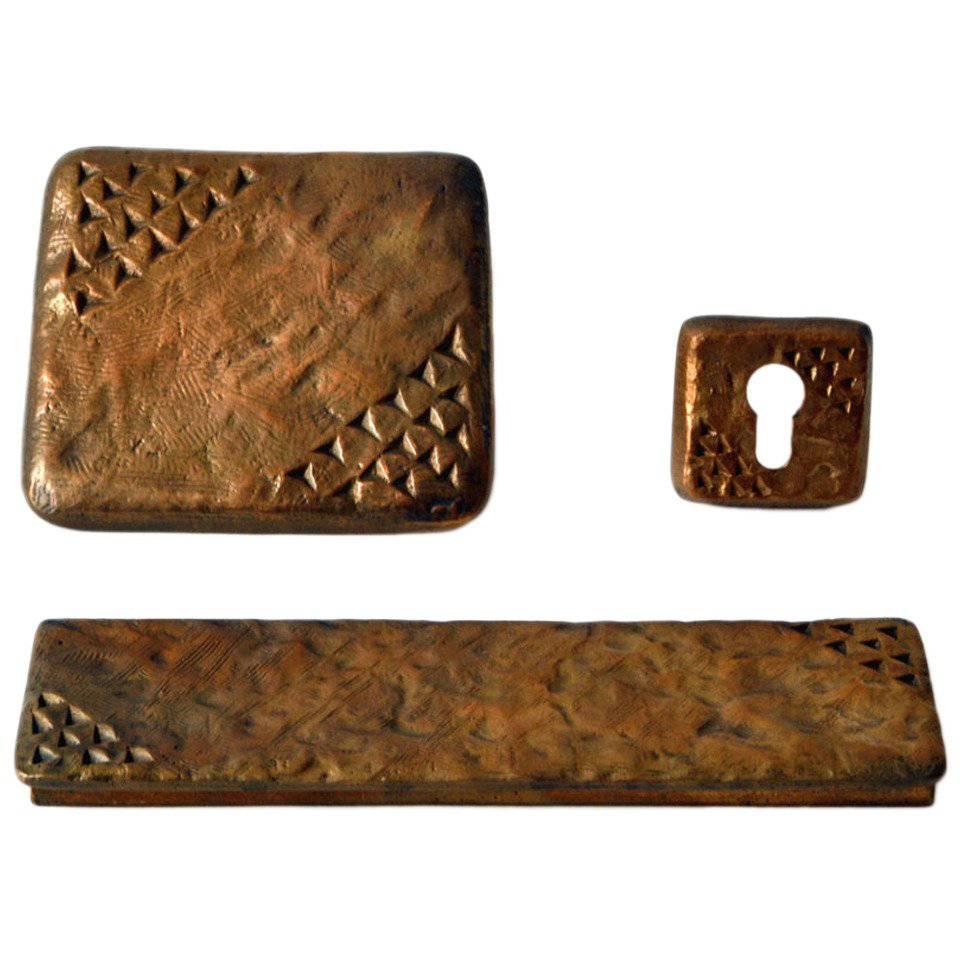 Two square cast bronze door handle, letter box and key holder with surface markings reminiscent of the Stone Age cave drawings.
The handle brackets are attached to the main plate by two fixings, they can be positioned in two ways, inwards outwards.