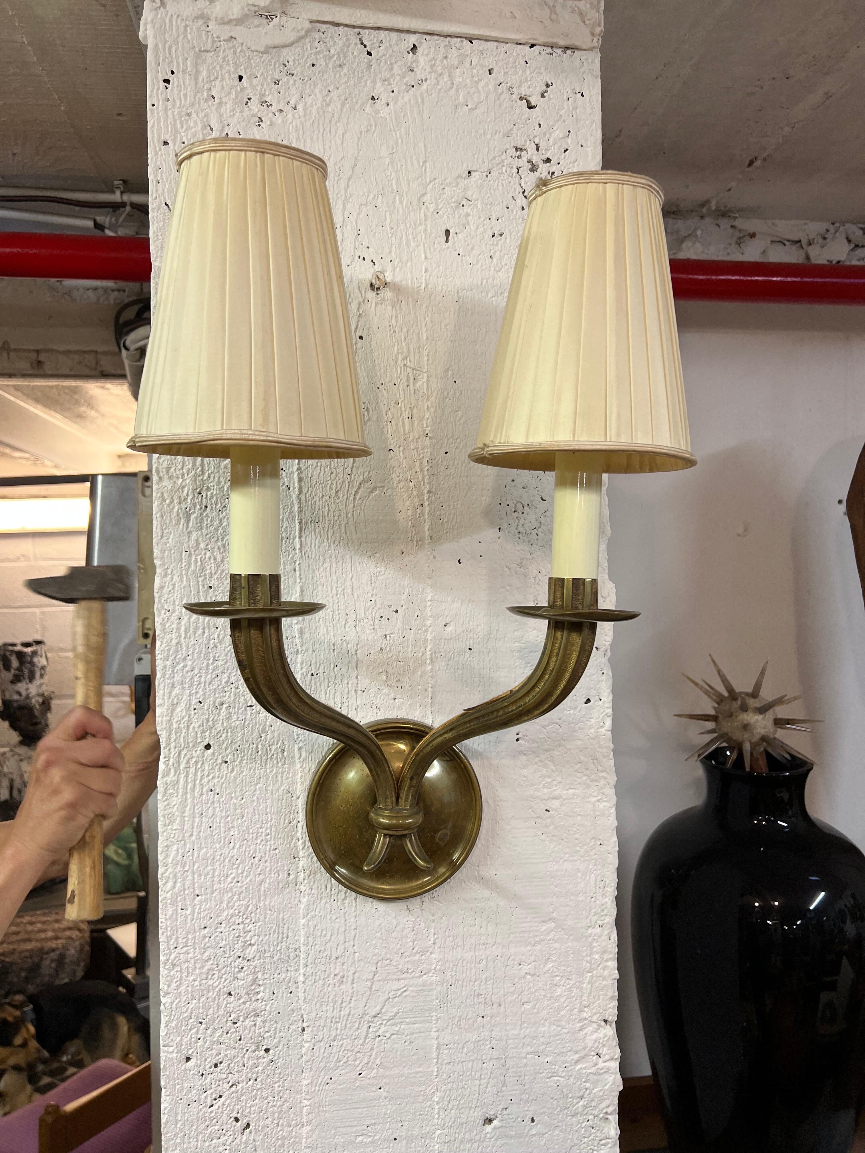 A bronze pair of sconces in the stile of Ruhlmann with original shades.