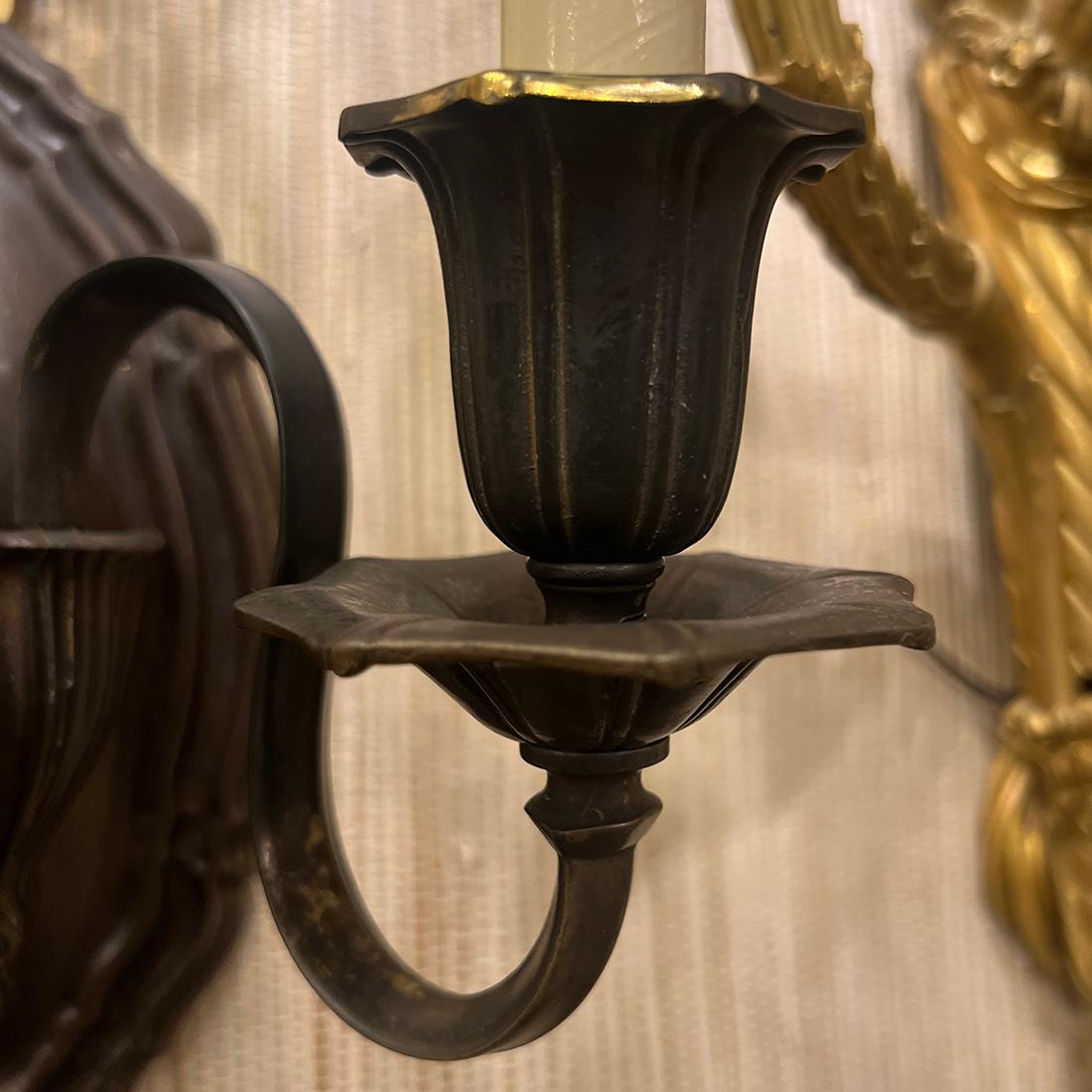A pair of circa 1920's American bronze sconces with original patina.

Measurements
Height: 11