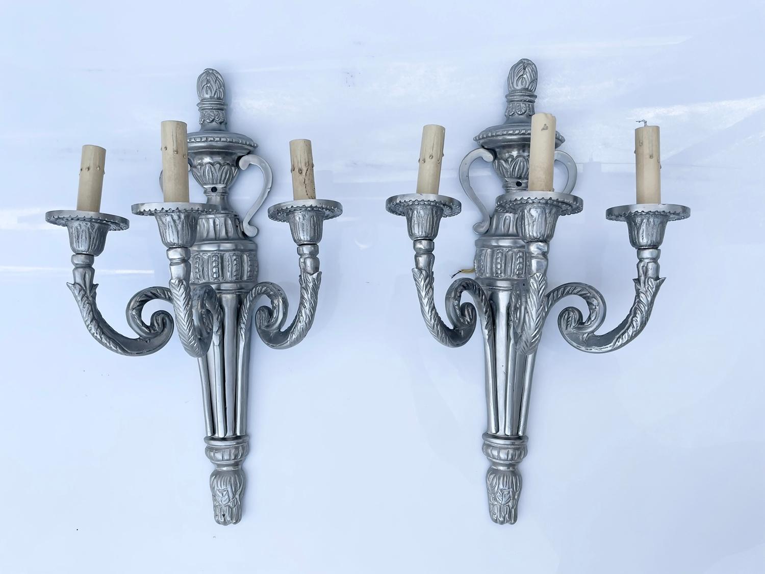 Introducing our exquisite Pair of Louis XVI Style Wall Lights, attributed to the renowned E.F. Caldwell & Co., a true testament to opulence and refined taste. 

Crafted with utmost precision, these stunning wall lights in a sleek silver finish are