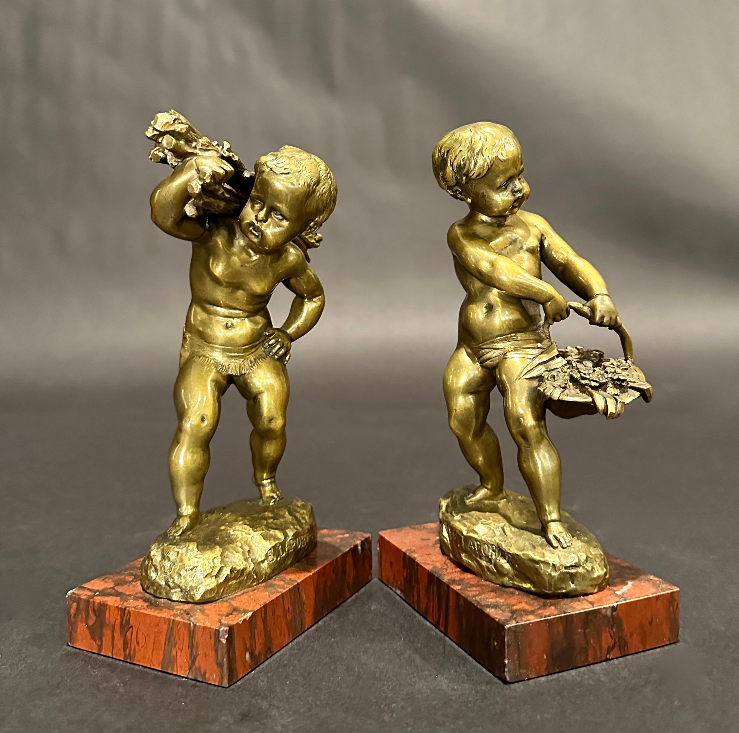 19th century French bronze sculptures of young farm boys by Emile Laporte (1858 - 1907), France. One boy carrying a basket of flowers, the other a bundle of sticks. Signed, mounted on rouge marble bases.