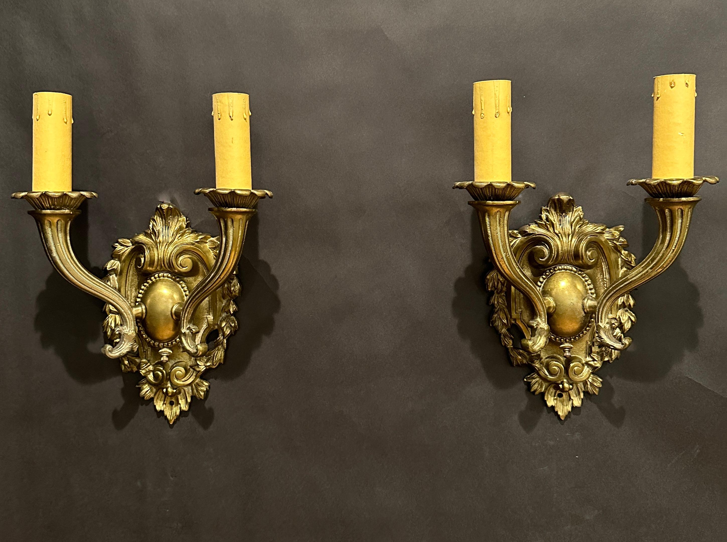 Nice pair of shield back bronze two arm wall sconces in  the  Renaissance Revival style with tapered cornucopia form arms.