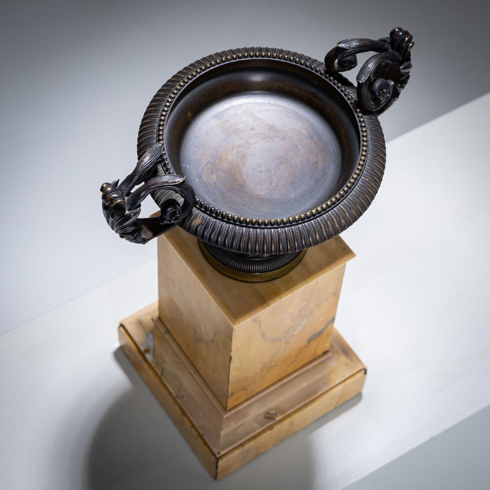 Pair of bronze tazzas in a neoclassical style, intricately crafted and mounted on square bases made of exquisite Siena marble. The combination of bronze and marble lends the tazzas a timeless elegance and a classical appeal.