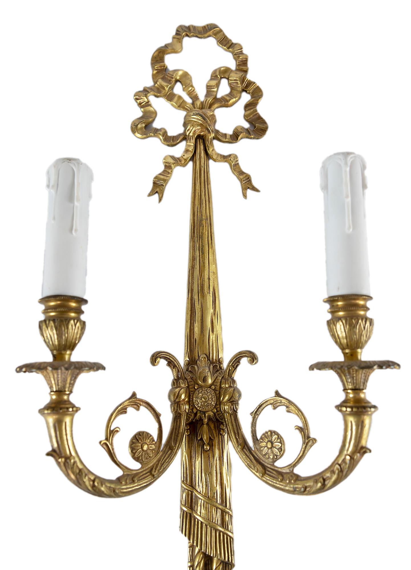 Pair of bronze wall light sconces in the form of ribbon.
Bulbs are E14 (2 pieces in each sconce).