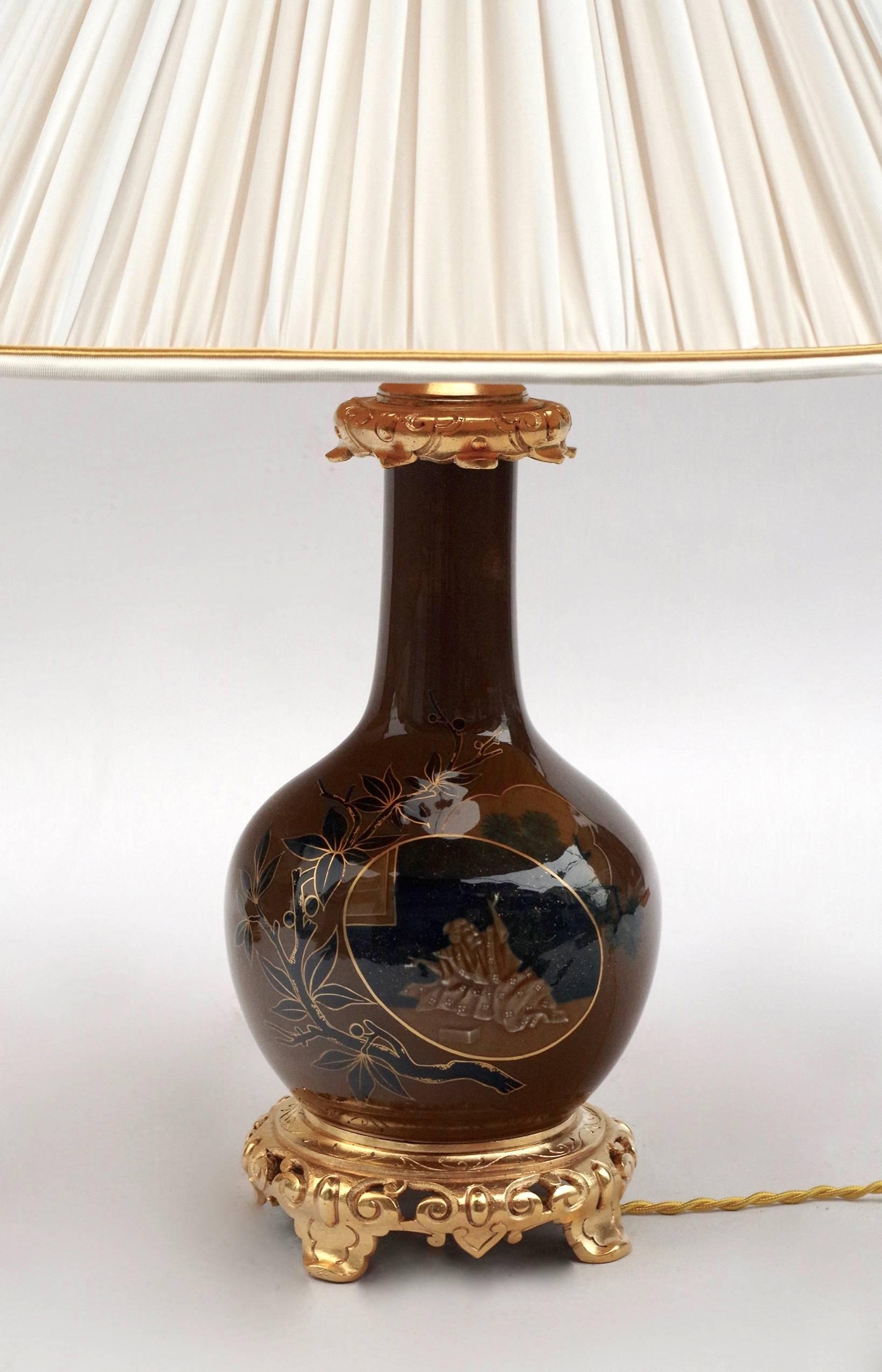 Paar balusterförmige Lampen aus braunem und blauem Porzellan. Dekoration von Figuren im japanischen Stil in einer Kartusche, umrahmt von Pflanzen und Blumen mit tiefblauen und goldenen Akzenten.
Montiert in gemeißelten und vergoldeten