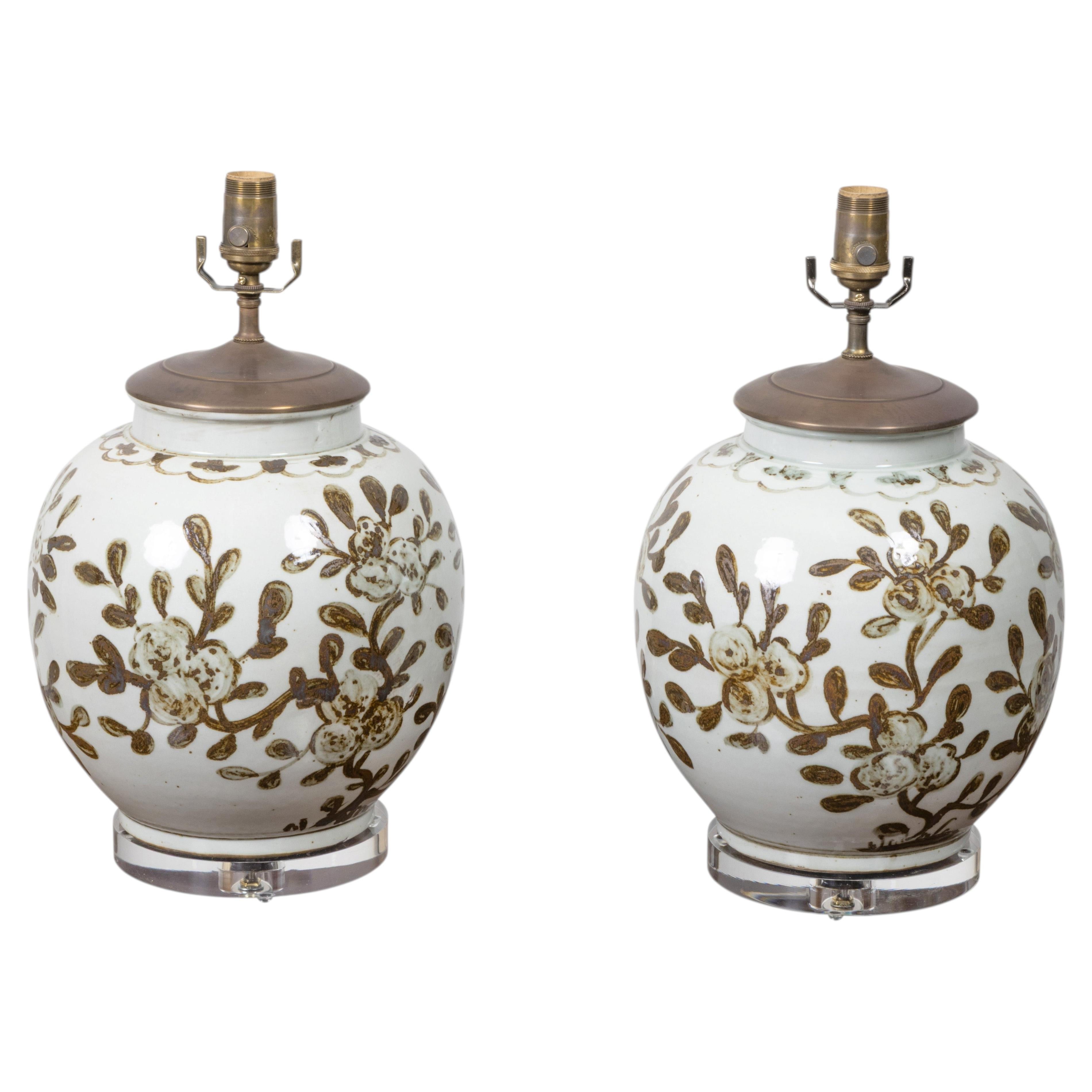 Coppia di lampade da tavolo in porcellana bianca e marrone su basi in lucite con decorazioni floreali