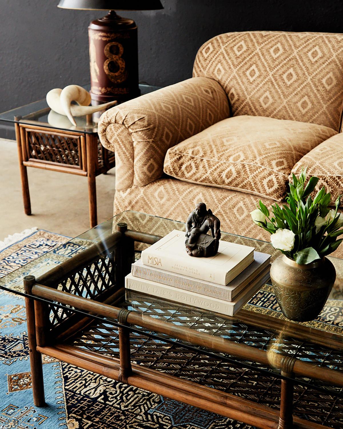 Near matched pair of bamboo rattan side or end tables made in the manner style of Brown Jordan. Almost identical but one table being 1.5 inches shorter than the other. Features a rattan frame with decorative stick wicker windows and reinforced with