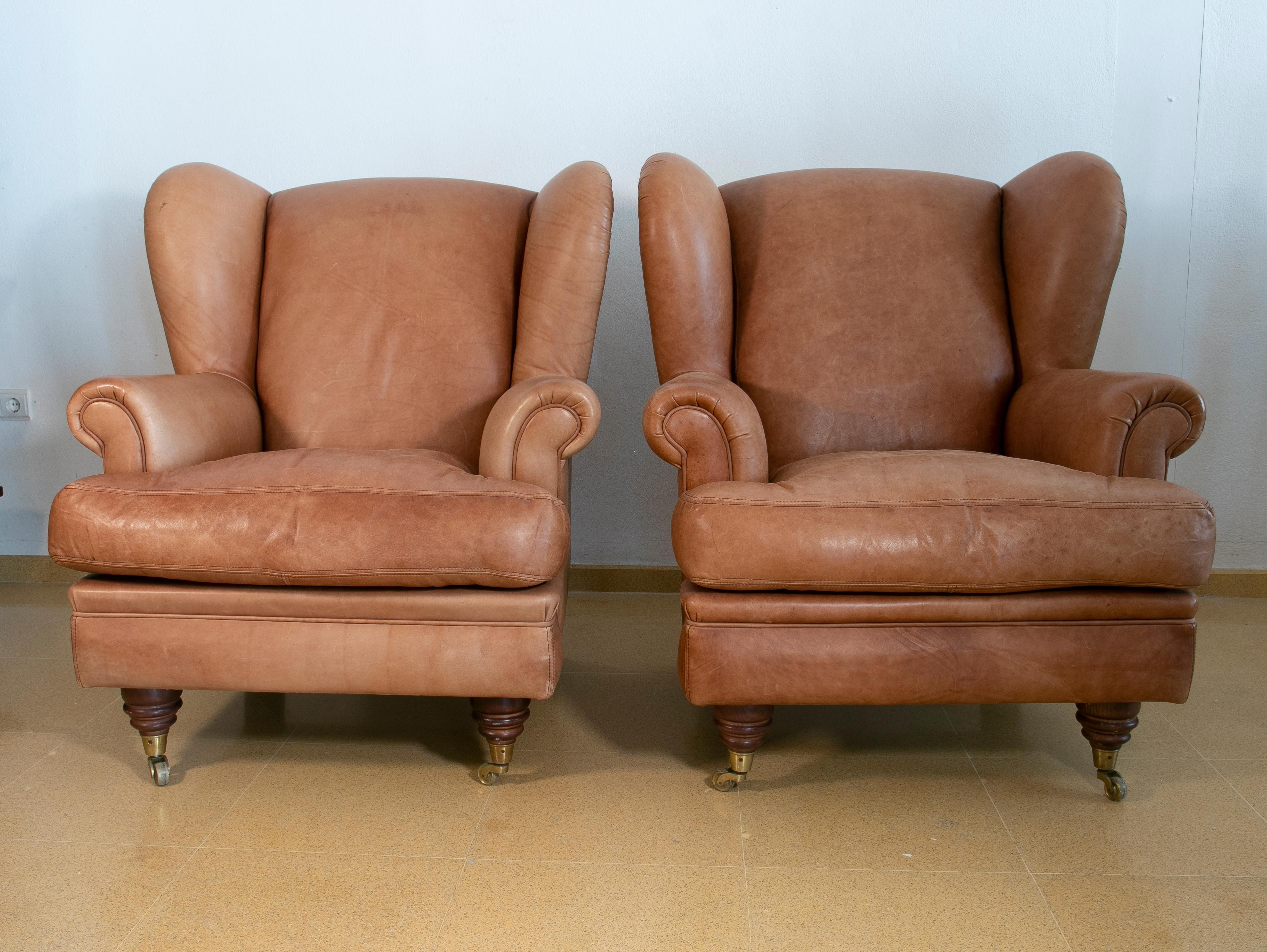 Pair of Brown Leather Armchairs with Wooden Legs and Brass Wheels In Good Condition For Sale In Marbella, ES