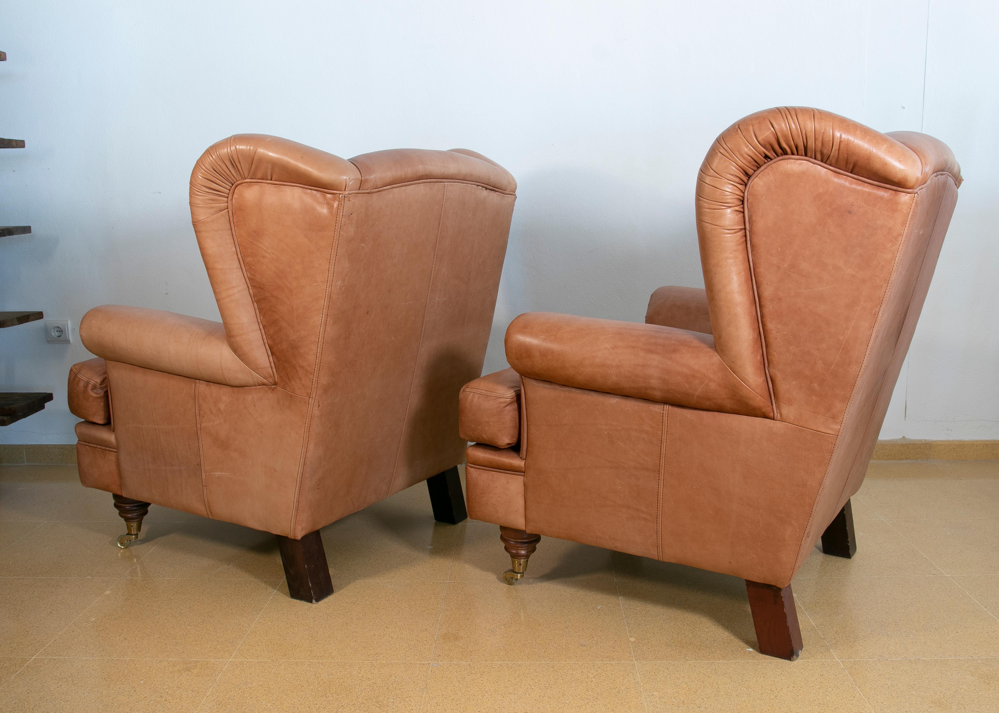 Pair of Brown Leather Armchairs with Wooden Legs and Brass Wheels For Sale 1