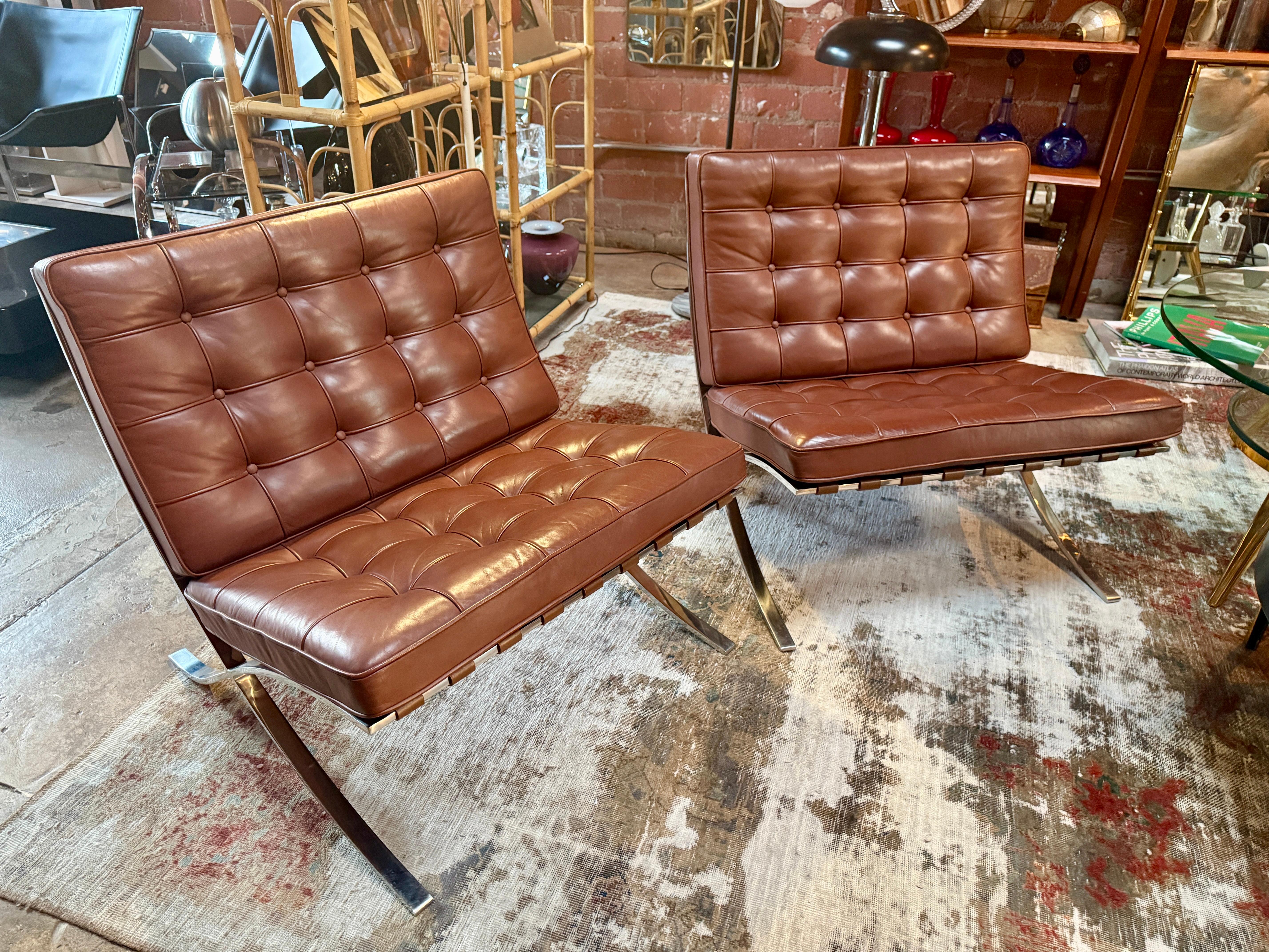 This pair of iconic Barcelona chairs, originally designed by Ludwig Mies van der Rohe in collaboration with Lilly Reich for the 1929 International Exposition in Barcelona, epitomizes the elegance and simplicity of modernist design. Crafted by Knoll