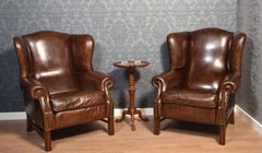 Pair of brown leather upholstered wingback armchairs