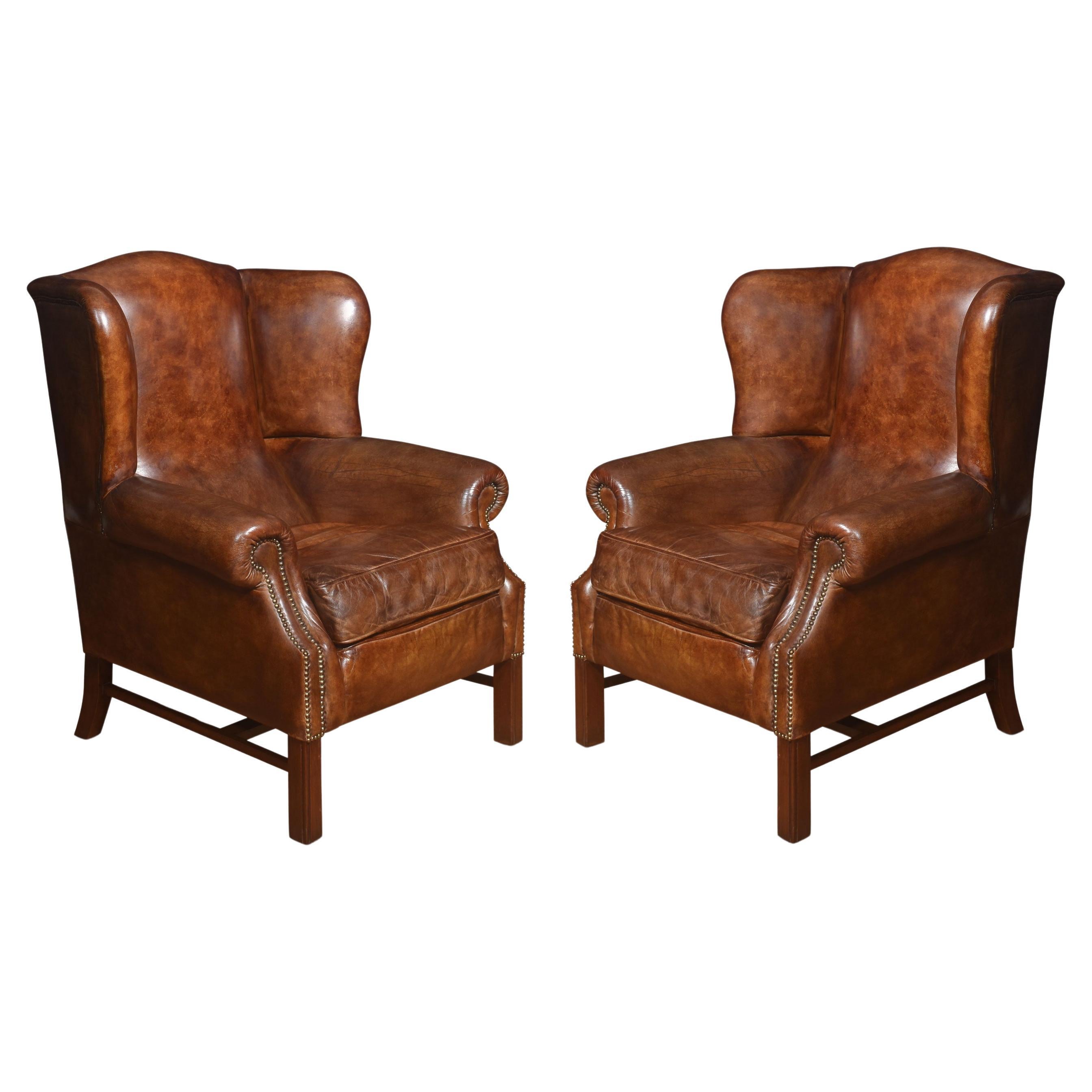 Pair of brown leather upholstered wingback armchairs