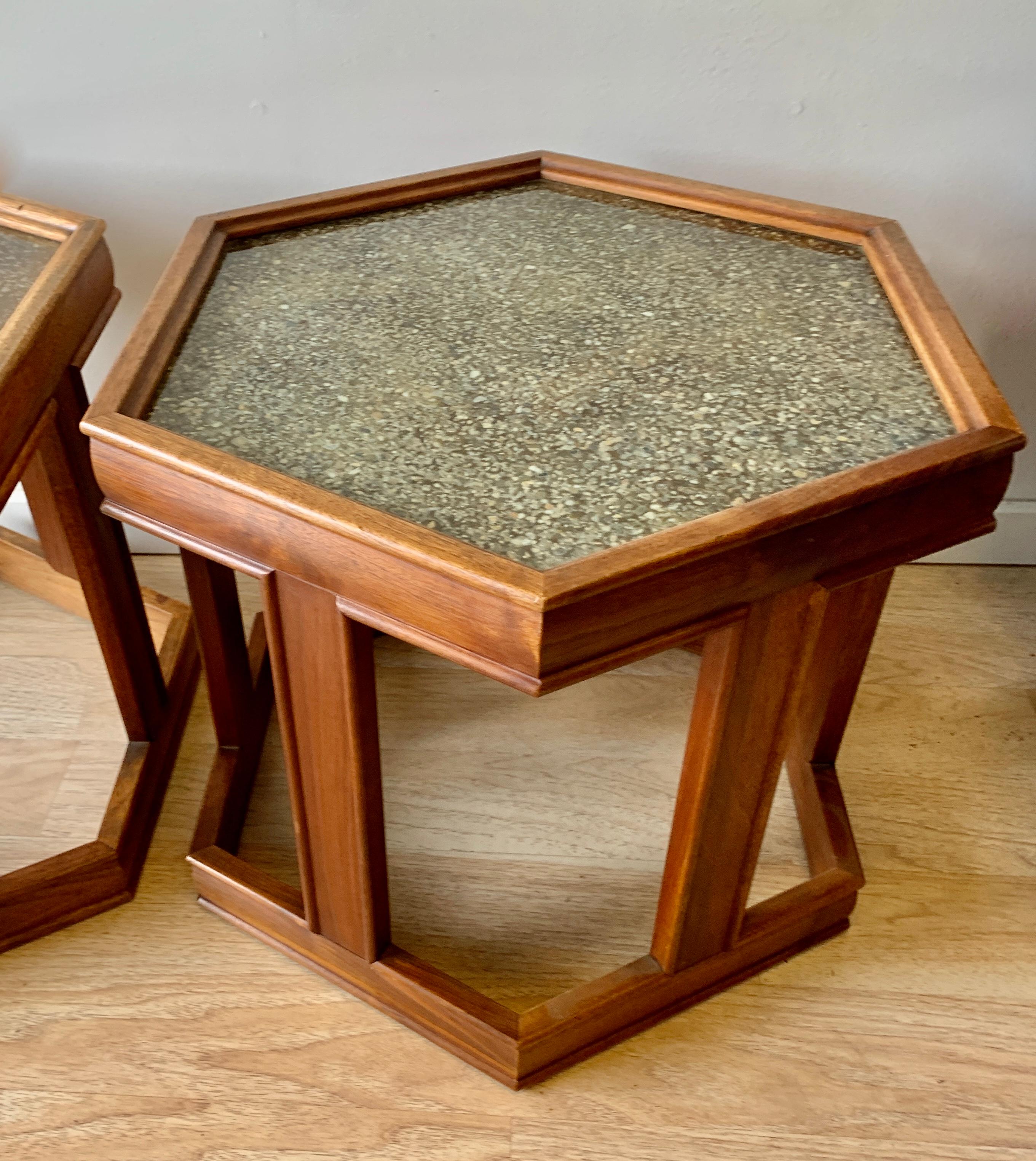 Pair of hexagonal side tables by Brown Saltman, designed by John Keal. Finished in medium walnut, with a brilliant reverse-painted and textured glass top in gold tones. The two can be used independently or as a pair to form a coffee table.