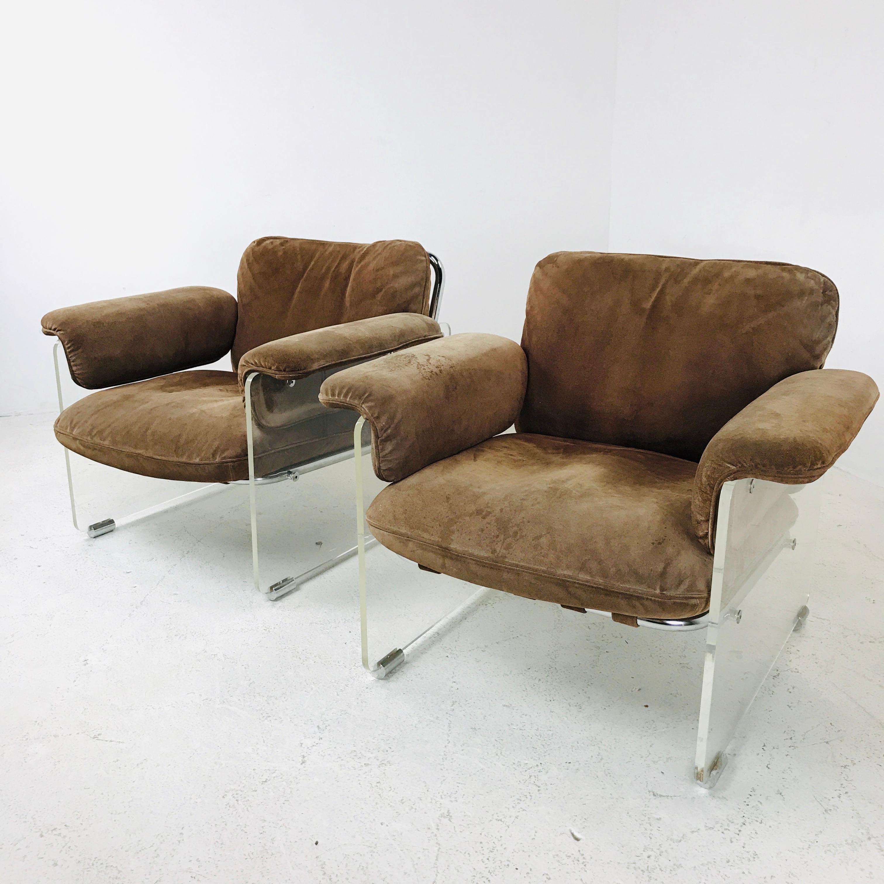 These eye-catching 1980s Pace lounge chairs feature thick Lucite panels with chrome details. Straps wrap the tubular chrome frame to support the cushions. This chairs are upholstered in brown suede which can be cleaned up or reupholstered in your