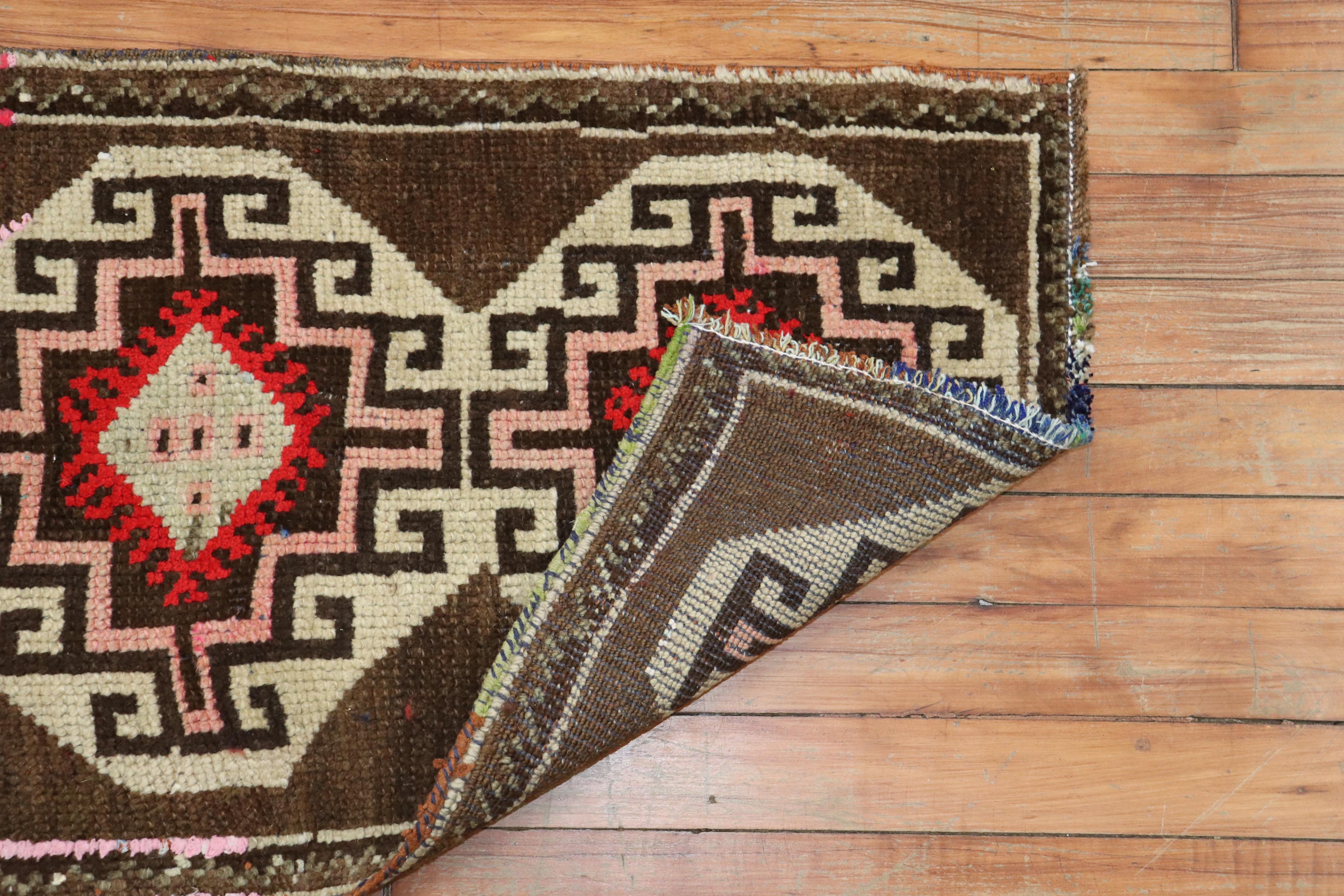 A matching pair of mid-20th century Turkish Anatolian rugs a tribal motif in red and white on a chocolate brown field

Measuring 18” x 33” and 18' x 35” respectively.