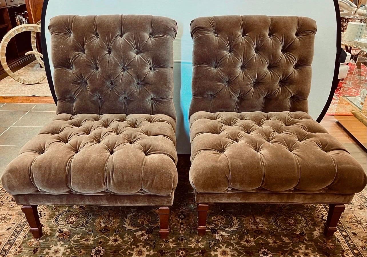 Luxurious brown velvet armless upholstered slipper chairs with rolled back and button tufting throughout creating a firm but comfortable sitting experience.