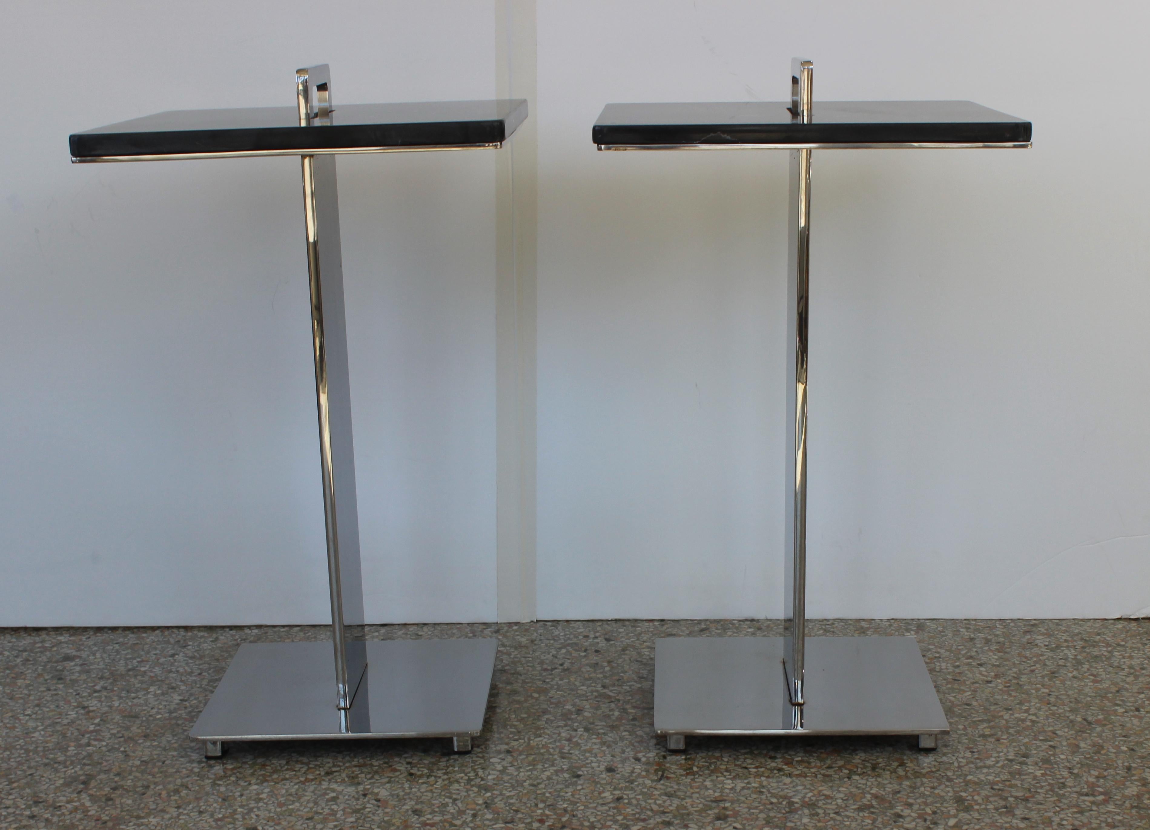 This stylish pair of custom tables are fabricated in polished steel and varigated black marble, and the pieces date to the 1990s. The pieces are very much in the manner of pieces created by the Brueton furniture company. 

Note: Dimensions of one