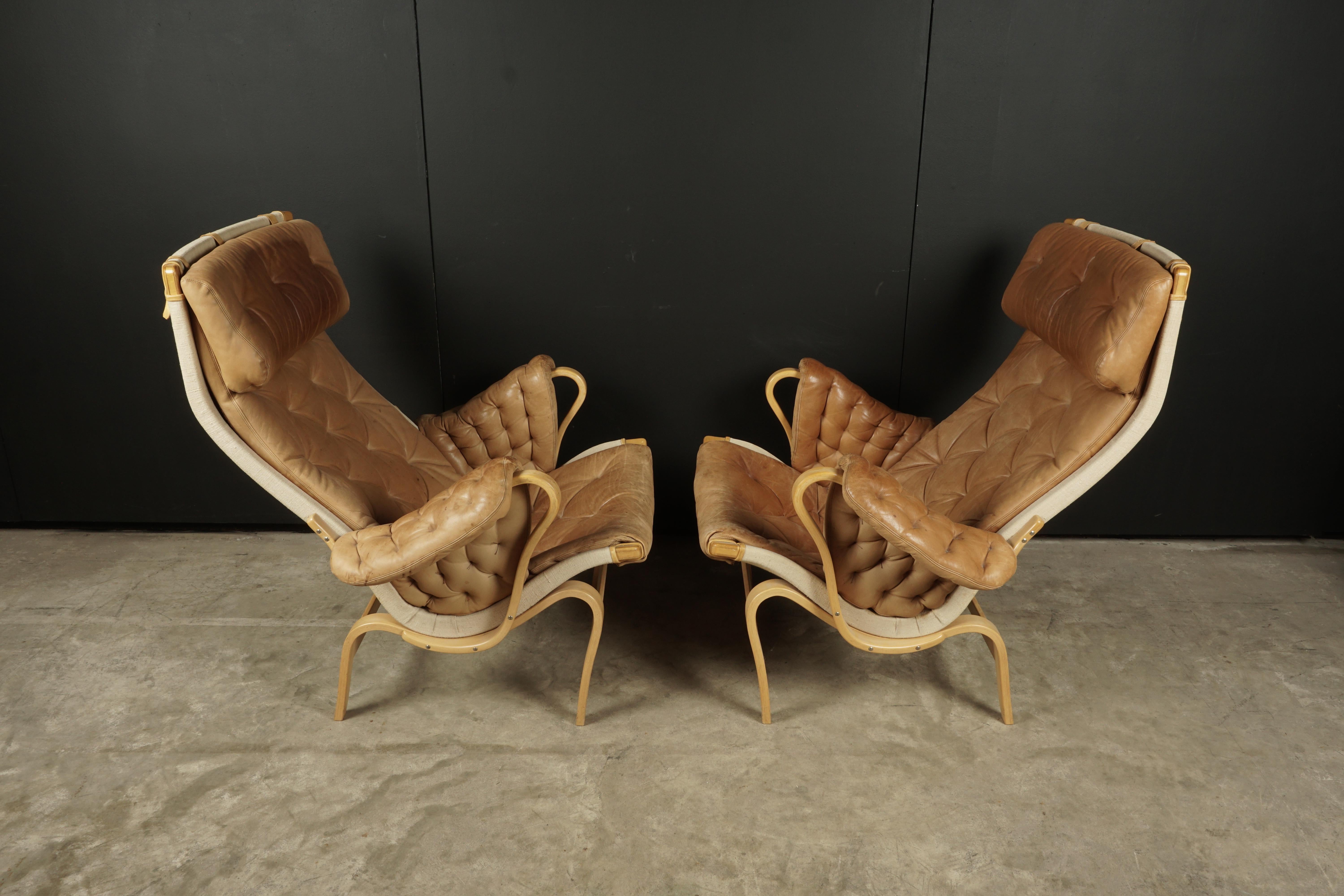 Pair of Bruno Mathsson Pernilla lounge chairs, Sweden, 1980s. Original tufted leather upholstery with a molded beech frame.