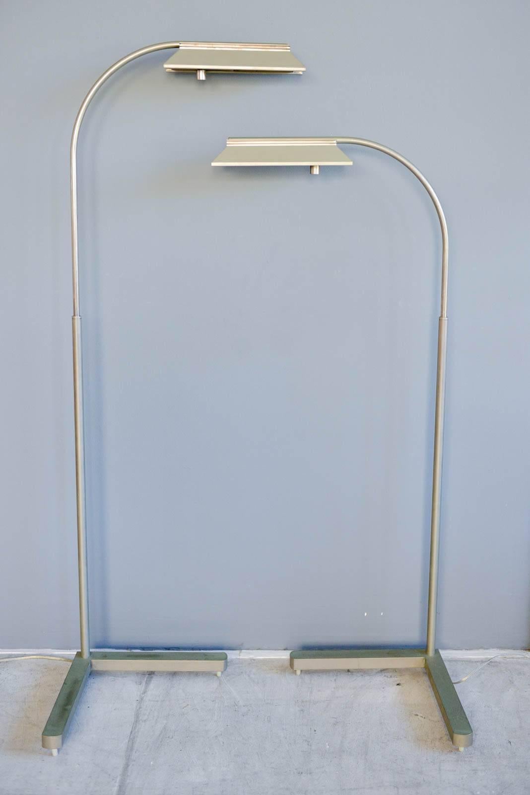 Pair of brushed nickel adjustable dimmable floor lamps by Casella, circa 1970. Good vintage condition, with original patina. Updated with new wiring. Dimmable and adjustable swing arm with heavy steel base. Perfect reading lamps next to chairs or