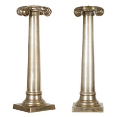 Coppia di candelieri a colonna in bronzo e argento spazzolato con grandi capitelli ionici