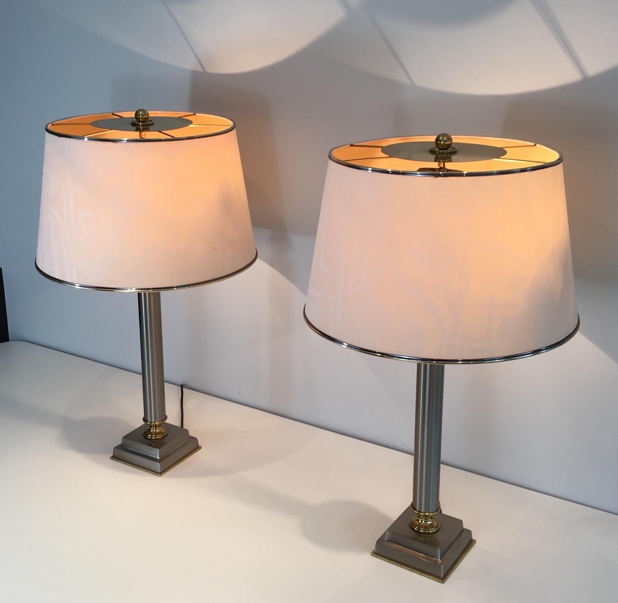 This important pair of table lamps is made of brushed steel and brass. These lamps are very simple with pure lines, in the style of neoclassical pieces but with a modern look. The shades can be reclined. This is a rare model by Guy Lefèvre, circa