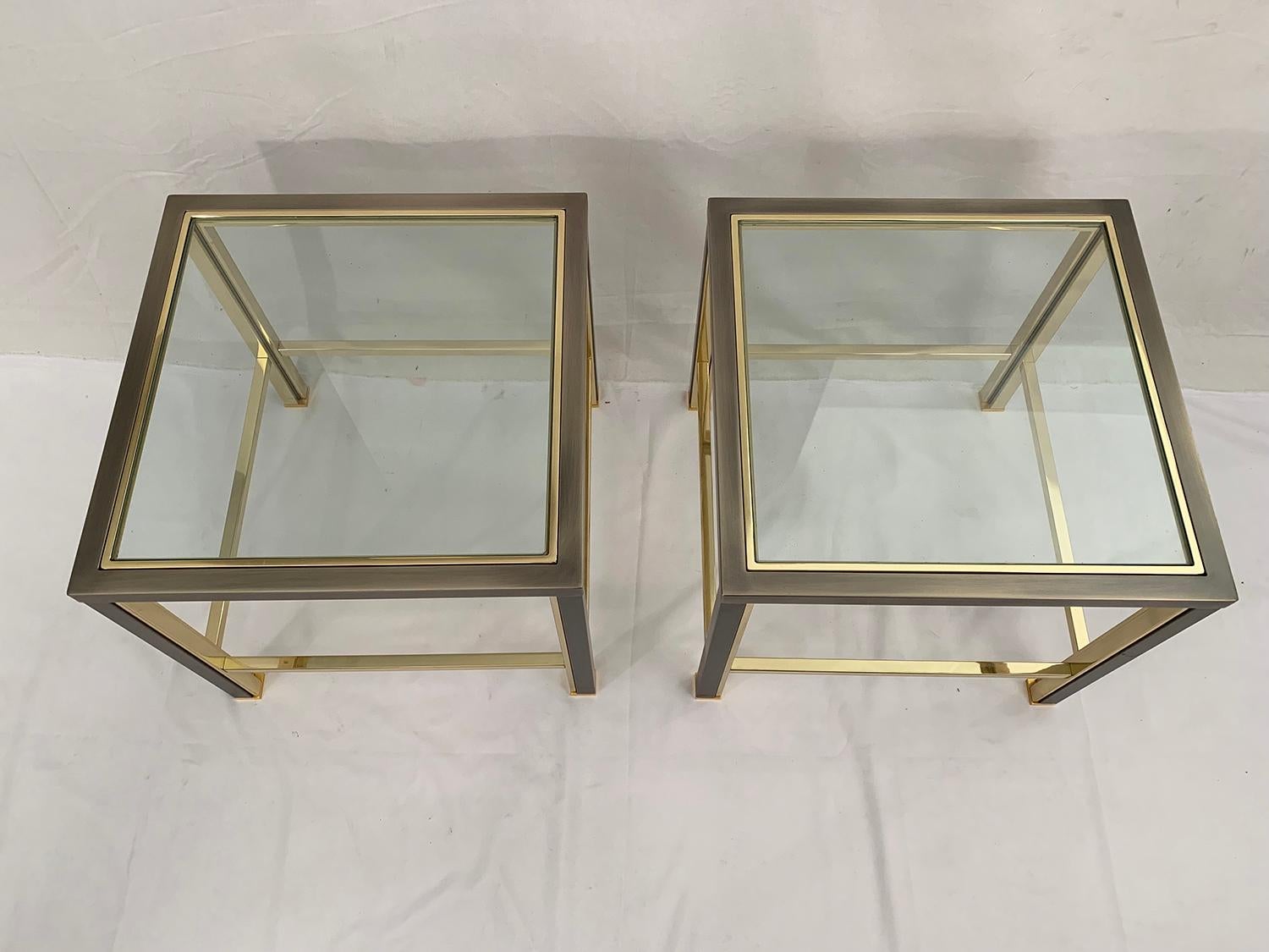 Splendid pair of side tables made of a brushed steel frame, enhanced by a gilded metal cladding and a glass top. The set manufactured and designed by Belgo Chrome dates from the 1980s.

Splendide paire de table’s d'appoint composées d'un cadre en