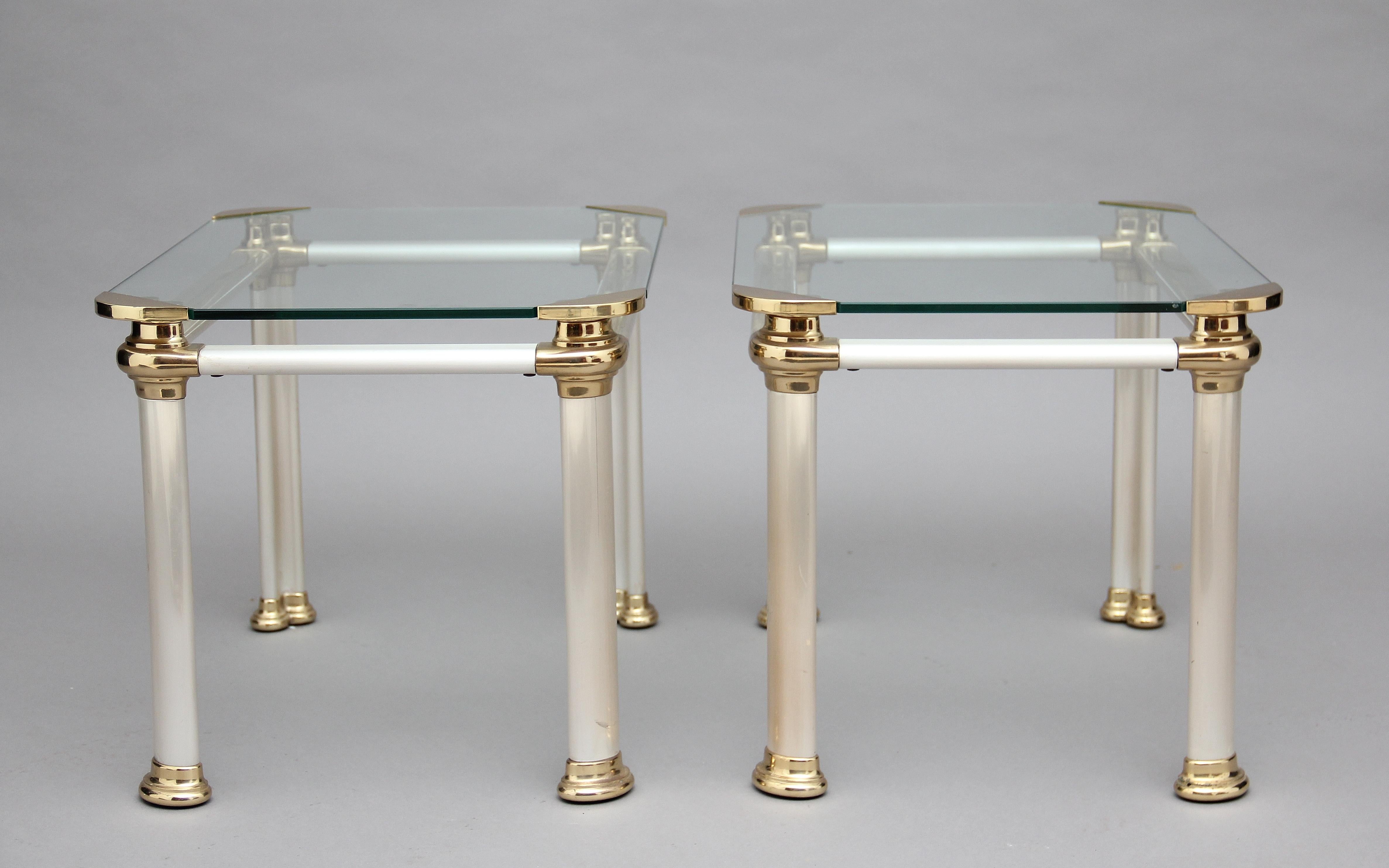 A decorative pair of mid-20th Century Italian brushed steel, brass and glass occasional tables, having a glass top with decorative brass corners, a brushed steel frame with four oval legs ending on brass caps. Lovely quality and in excellent