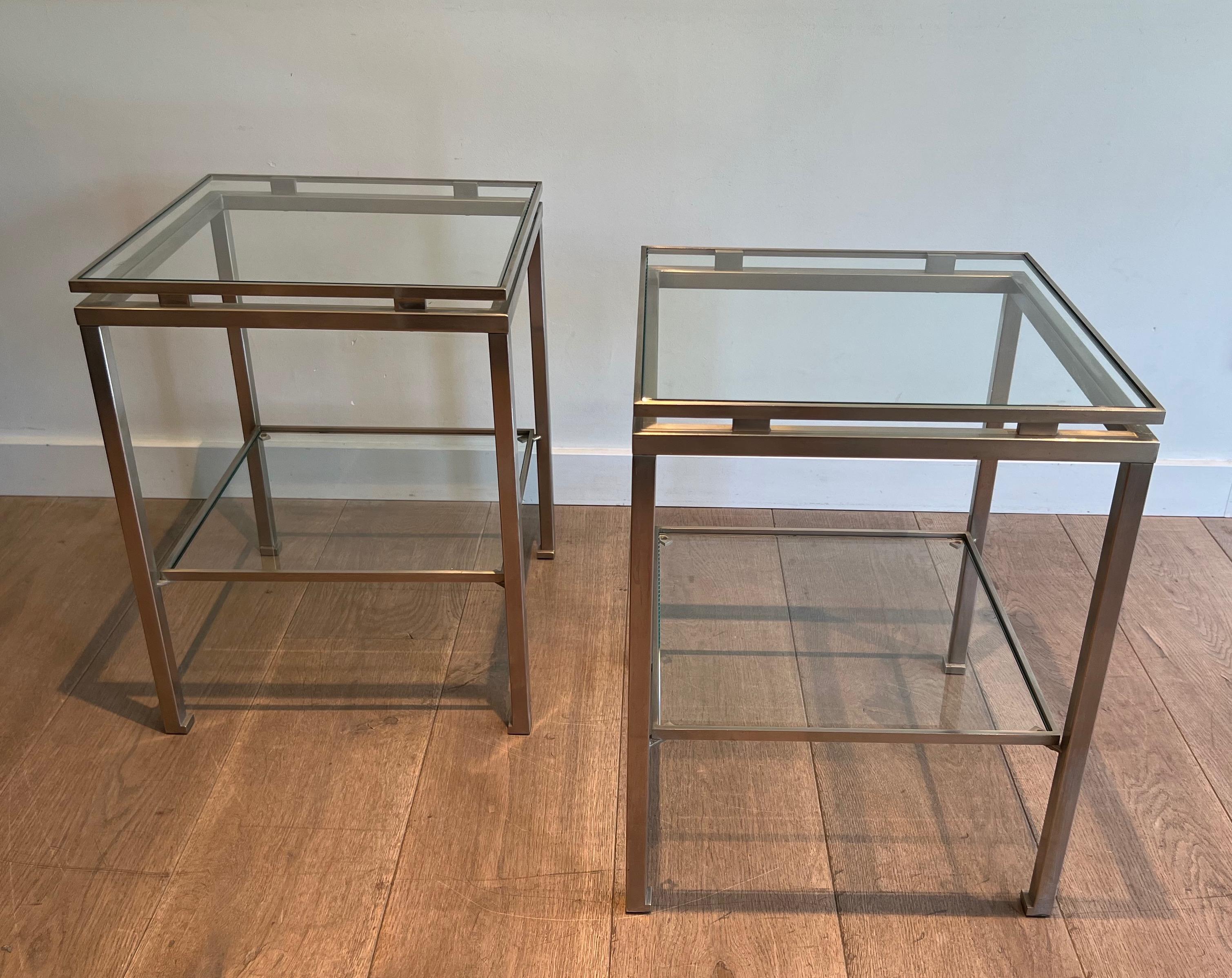 This nice pair of side tables is made of brushed steel with clear glass. The fact the 2 top frames are separated by small rectangular links and the way the feet are made is typical by Guy Lefèvre. These side tables have been designed and made by
