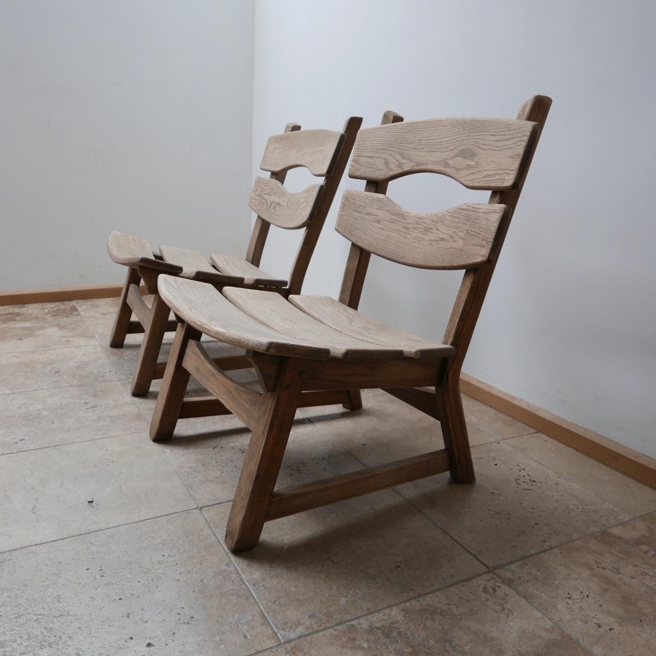 A pair of solid oak easy chairs. 

Belgium, c1970s. 

Stripped wood which could be waxed or coloured to taste.

In the manner of 'De Puydt'. 

Comfy and stylish, but could easily be enhanced with the addition of a sheepskin for some warmth.