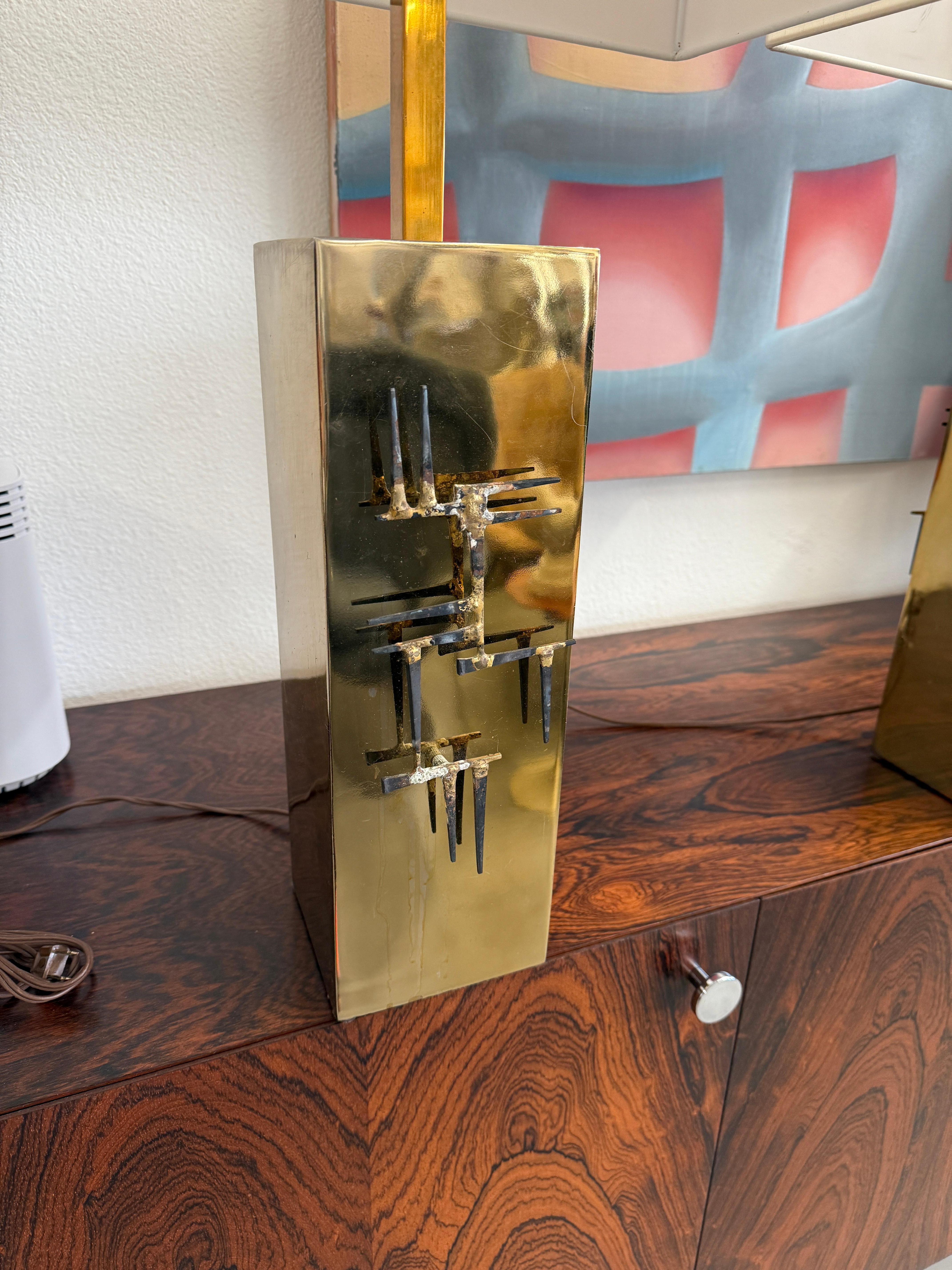 Una meravigliosa coppia di lampade brutaliste di Laurel Lamp Company. Presentano decorazioni con chiodi saldati su entrambi i lati delle lampade, che sono in ottone. I paralumi hanno una bella forma rettangolare che si adatta alle lampade. Sono