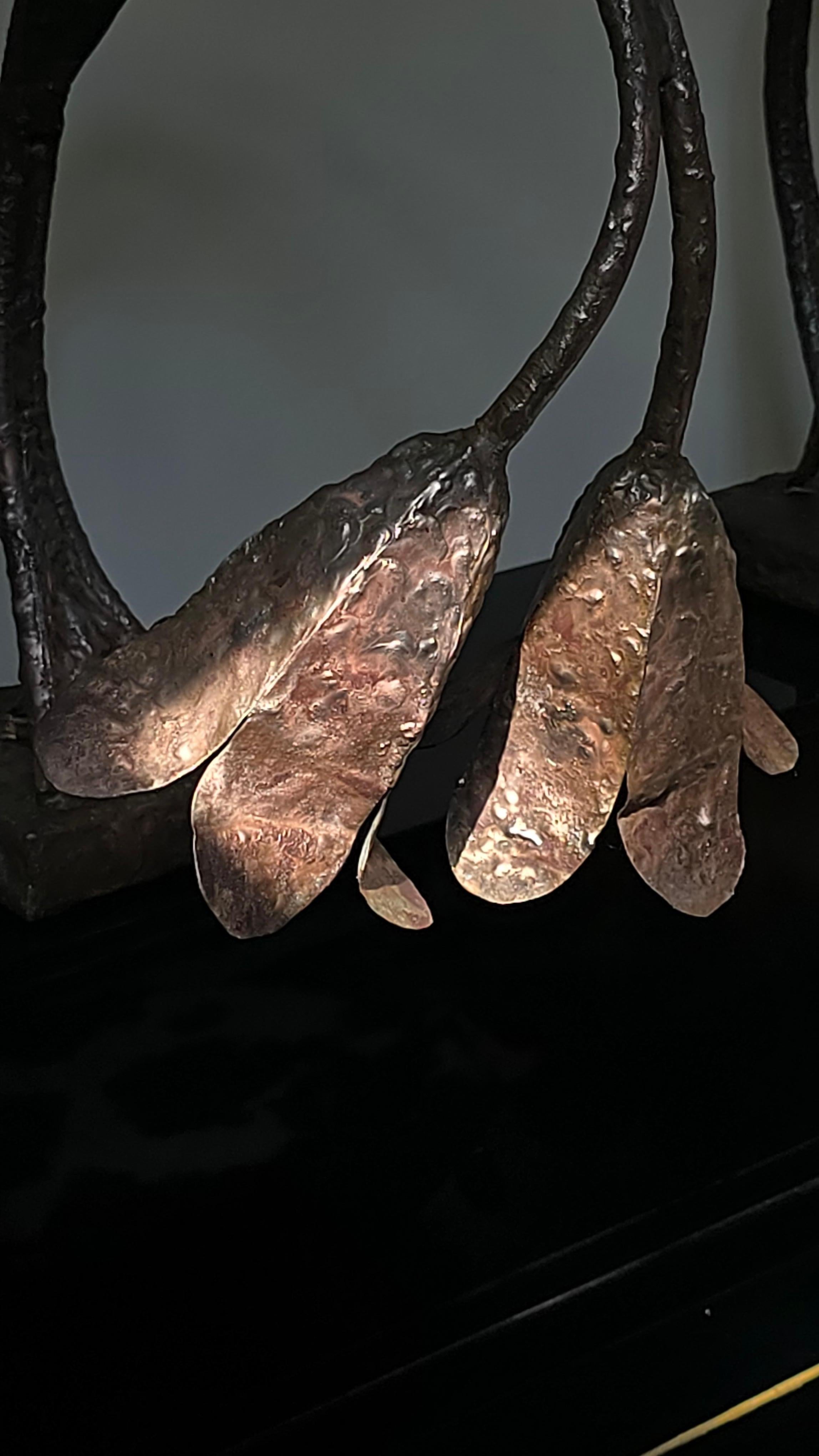 Striking pair of Brutalist wall sconces in patinated bronze, handcrafted in Germany in the 1960s. Each piece evokes the sculptural elegance of wilted flowers or organic forms, with raw textures and an expressive, hammered finish. A rare example of