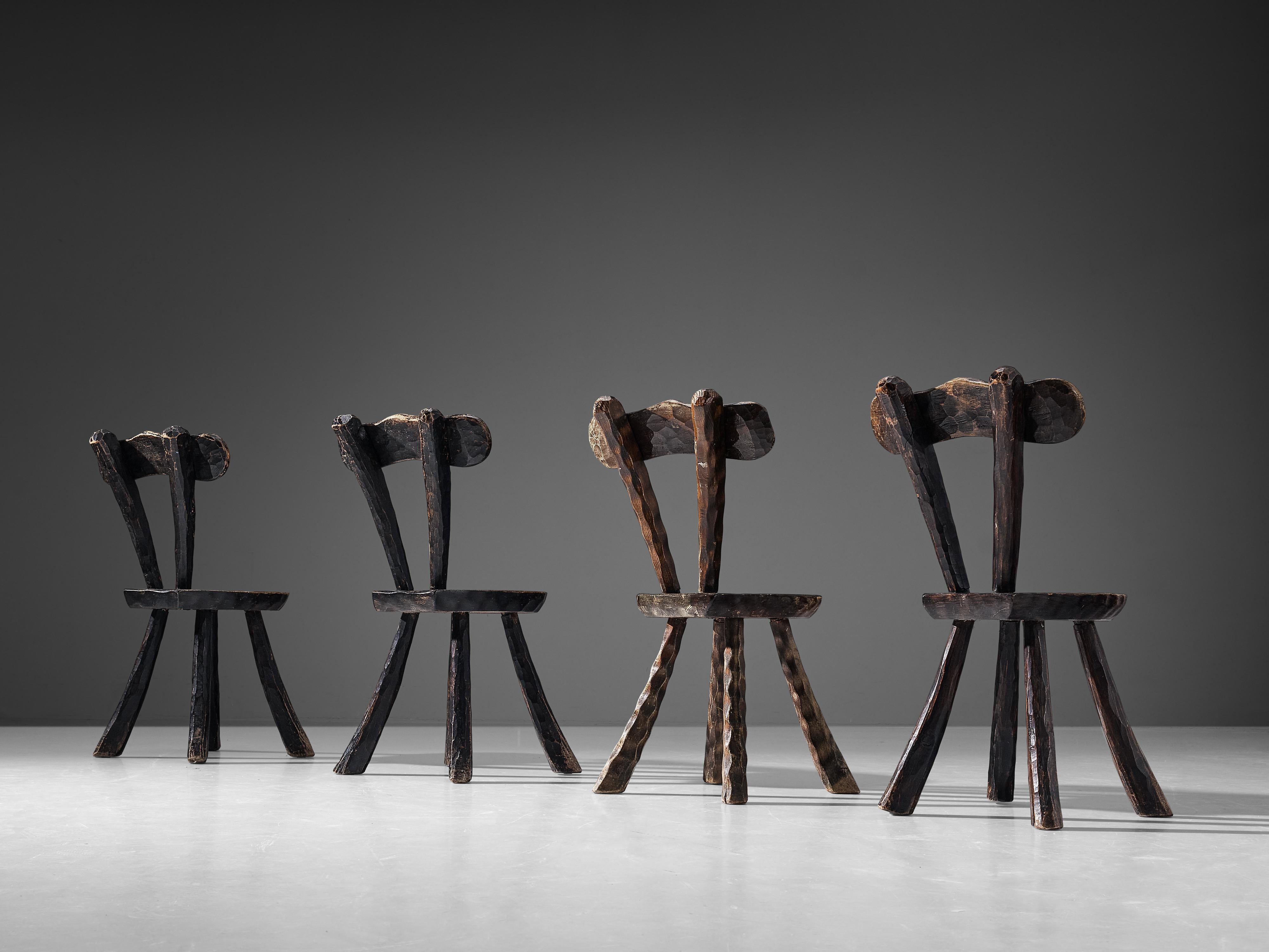 Pair of side chairs, dark stained elm, France, 1960s. 

Pair of Brutalist chairs in the manner of Alexandre Noll. These French chairs show the characteristic traits of his furniture designs; the frame exhibits prominent carving details creating a