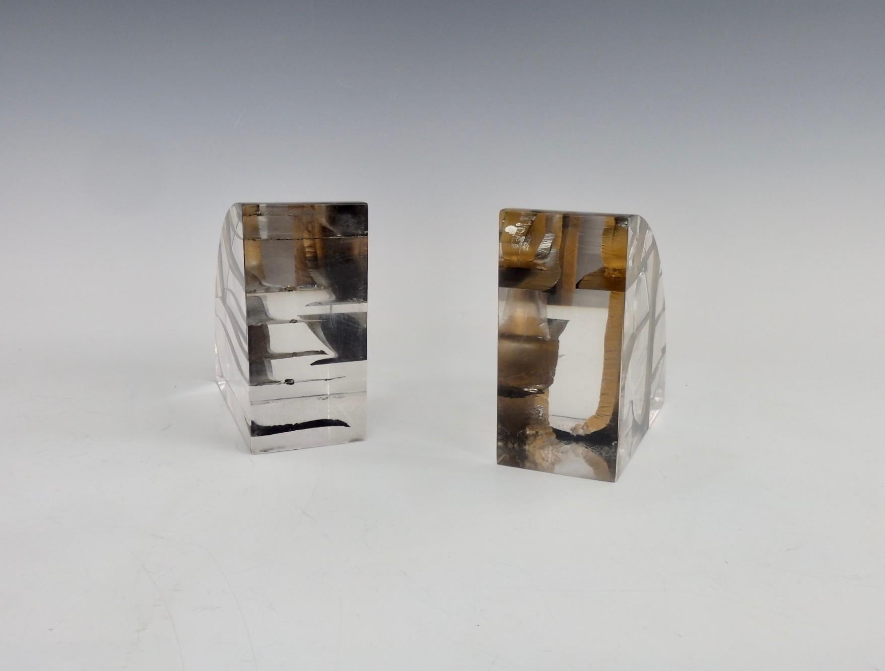 Pair of quarter circle Lucite book ends. Each having steel ribbon twisted and turned inside the acrylic body.