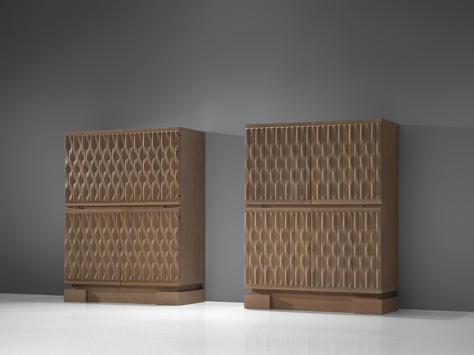 Brutalist sideboard, in oak, Belgium, 1970s. 

Sturdy high-board in oak with graphical designed door panels. Four door panels, each with a exceptional three-dimensional pattern. The continuous pattern gives this bar-cabinet a very strong expression,
