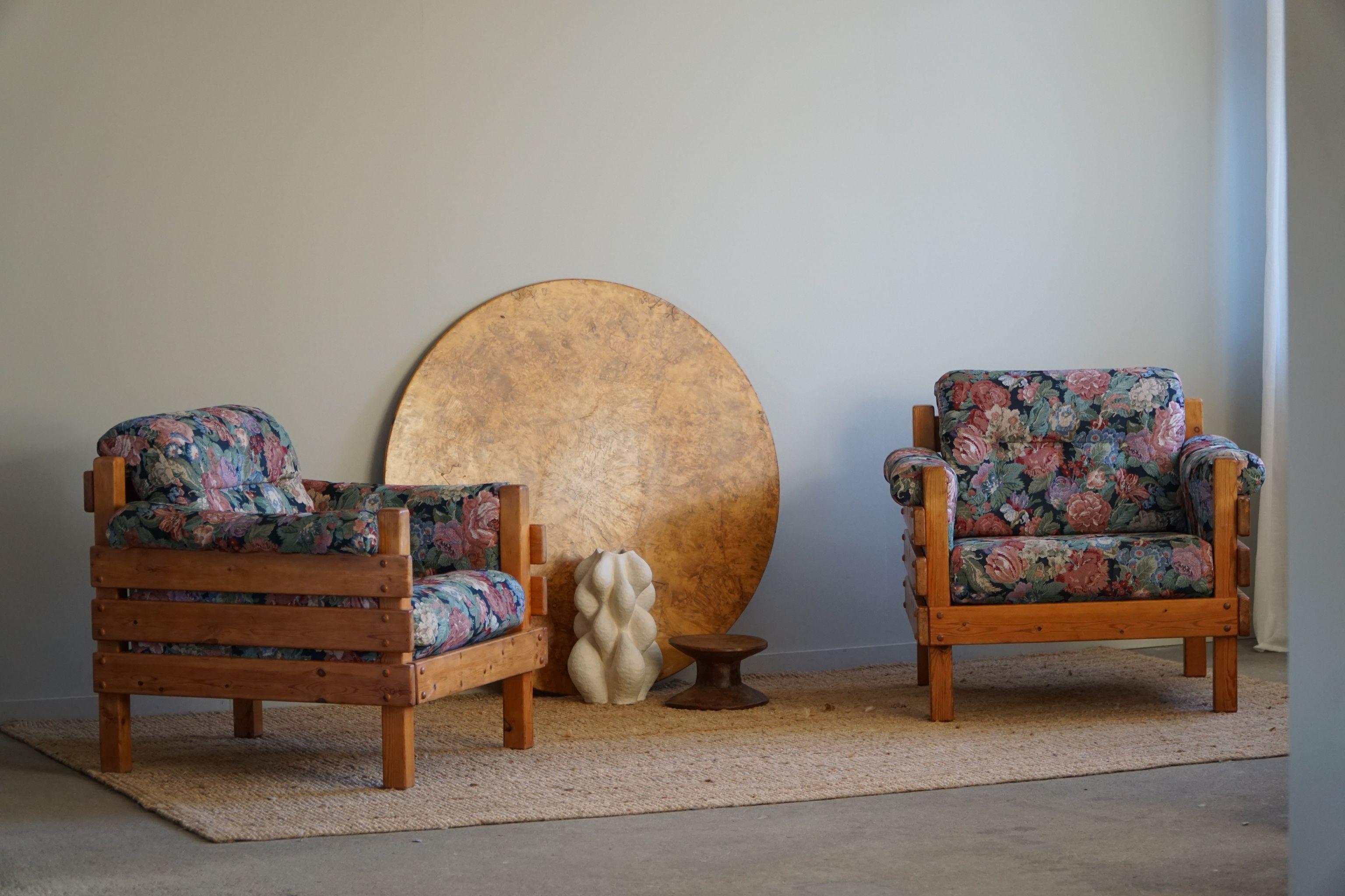 Une paire sculpturale de chaises longues en pin massif, tapissées d'un tissu vintage coloré. Attribué au designer suédois Sven Larsson. Fabriqué dans les années 1970.

Cette paire brutaliste s'harmonise avec de nombreux styles d'intérieur. Une