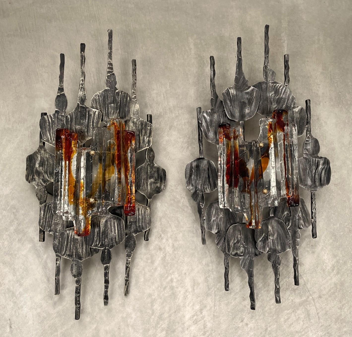A pair of Sculptural Scandinavian Modern Glass Metal Sconces by Tom Ahlstrom Hans Ehrich 1970s - A hand-wrought iron surround holds an amber and clear Murano ice glass - gives a beautiful warm effect when lit. Stunning Swedish industrial design.