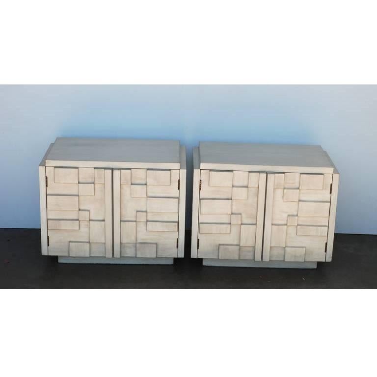 These cubist effect Brutalist style nightstands refinished in a driftwood finish are manufactured by Lane. The doors open to reveal one shelf. The Brutalist styling on the block fronts is a reference to the Paul Evans Cityscape line.
