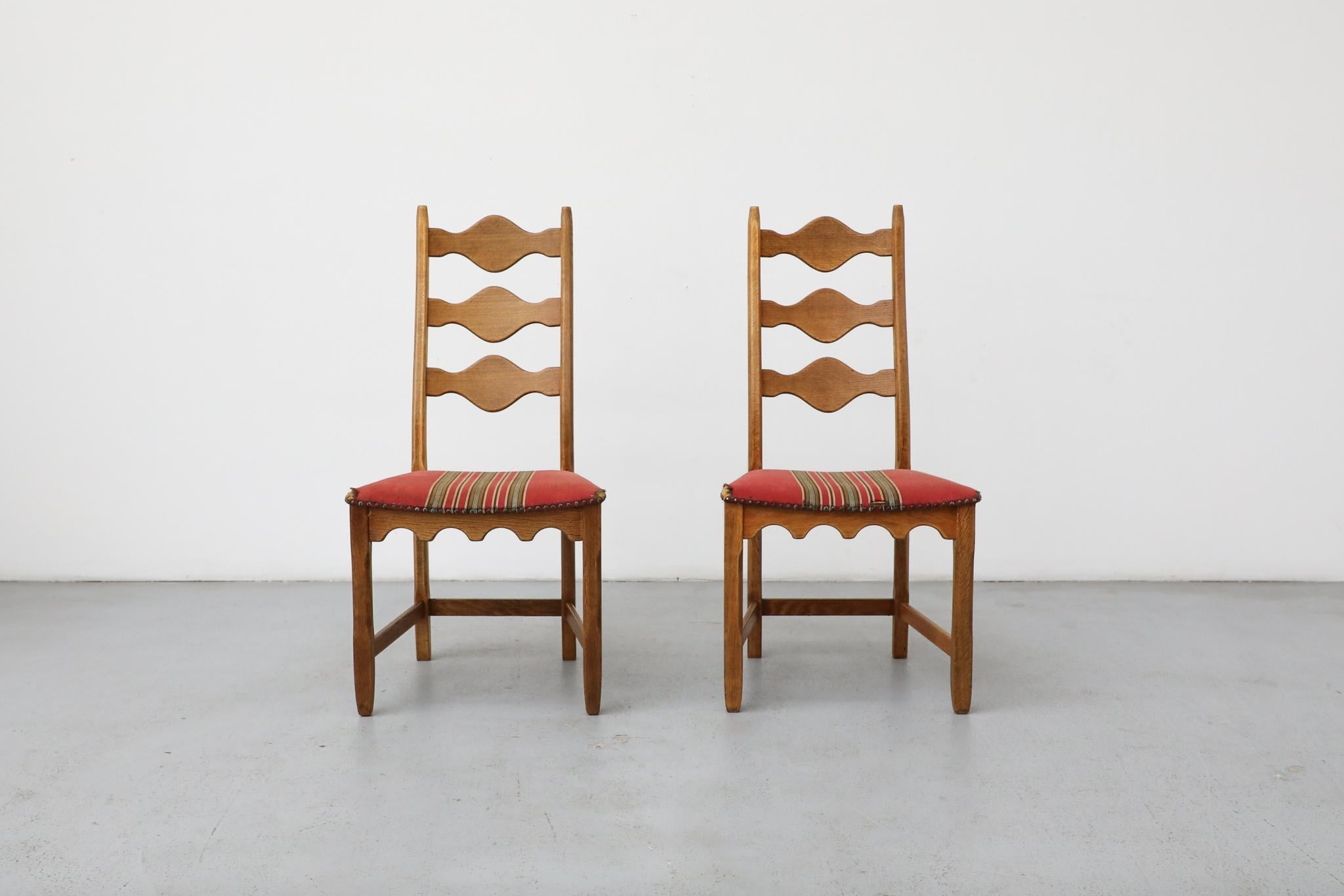Brutalist decorative back, throne-like oak chairs designed by Henning Kjaernulf. These chairs have a solid oak frame with an undulating decorative design theme and original red and green striped upholstered seats. Upholstery in very original and