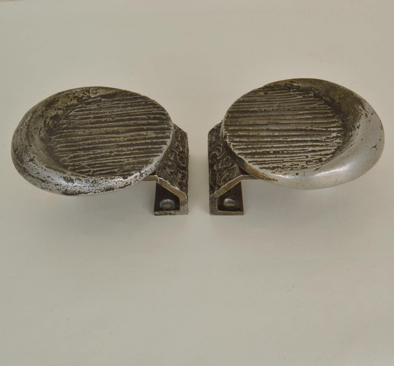 Pair of Brutalist round push and pull door handles with relief. cast in aluminum with a original patina giving the relief depth. These artistic door features work on both exterior and interior doors; on both sides of a single door or next to each