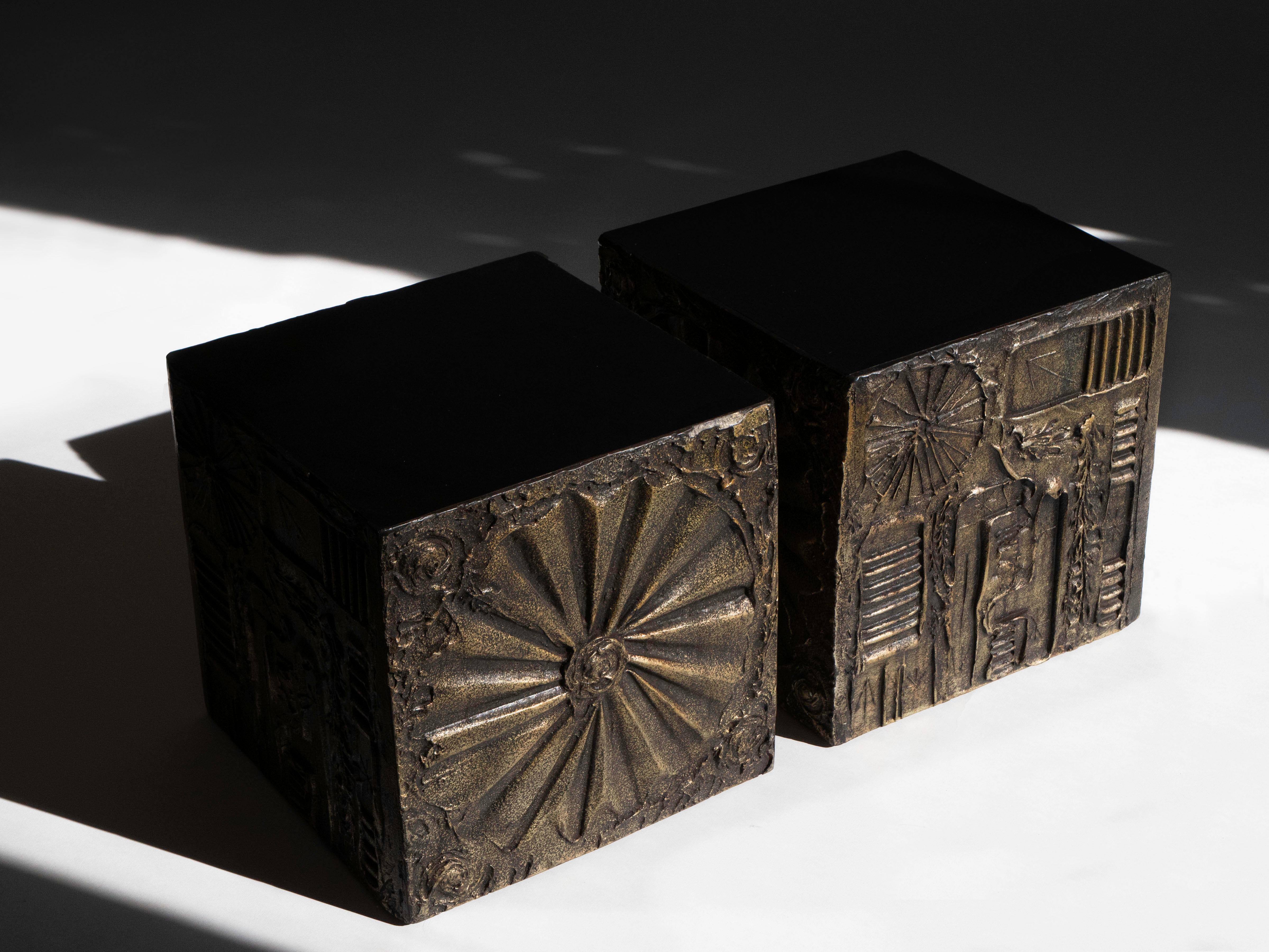Pair of brutalist side tables or display pedestals by designer Adrian Pearsall for Craft Associates, circa 1970's. The frames are comprised of solid wood adorned with sculpted resin and finished in bronze. There are alternating designs on each face