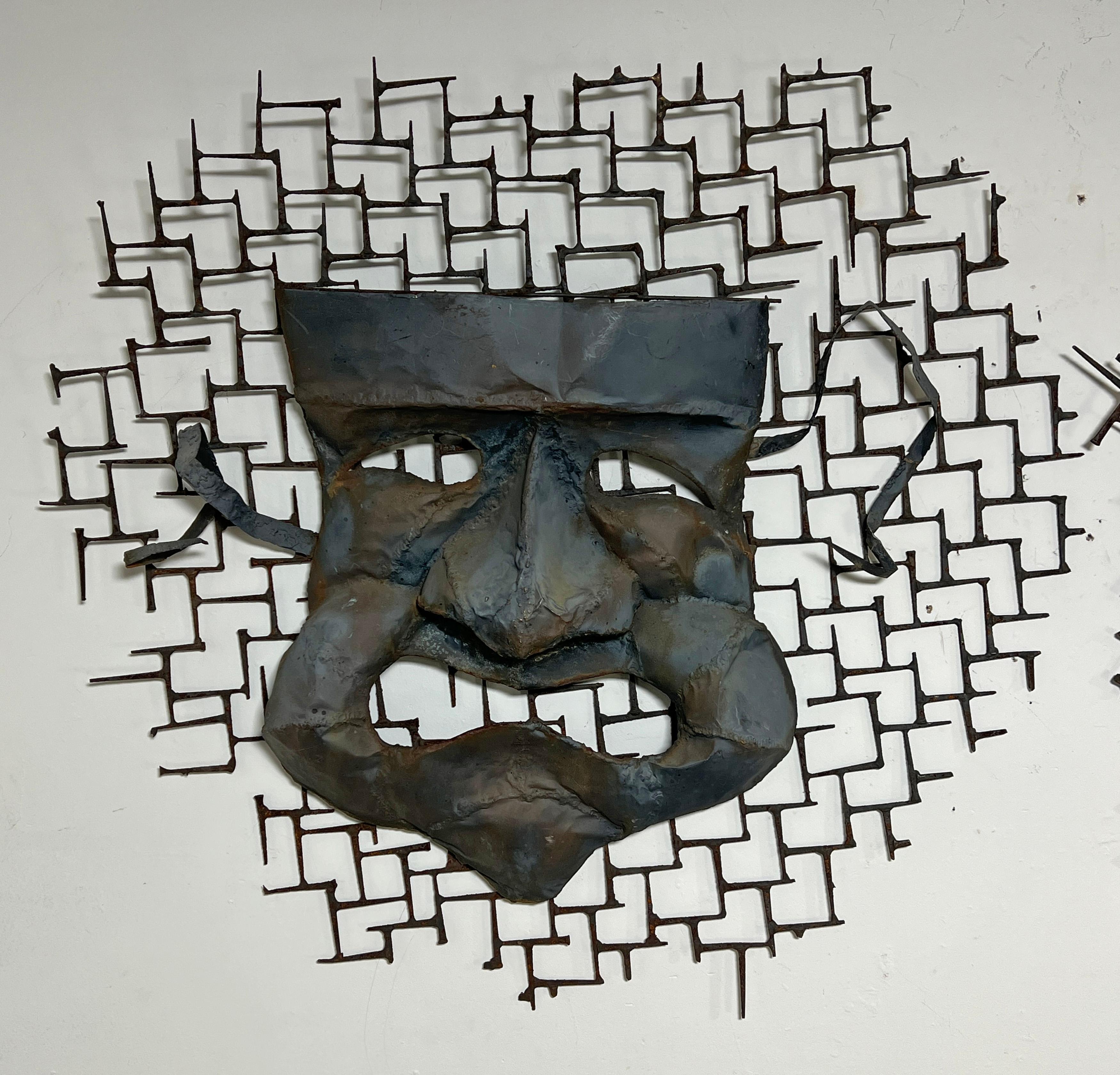 Un par de esculturas murales de gran tamaño de los años 50, a la manera de Frederic Weinberg, que representan las clásicas máscaras de comedia (Talía) y tragedia (Melpómene). Elaboradas en bronce martillado y enmarcadas en una greca de clavos