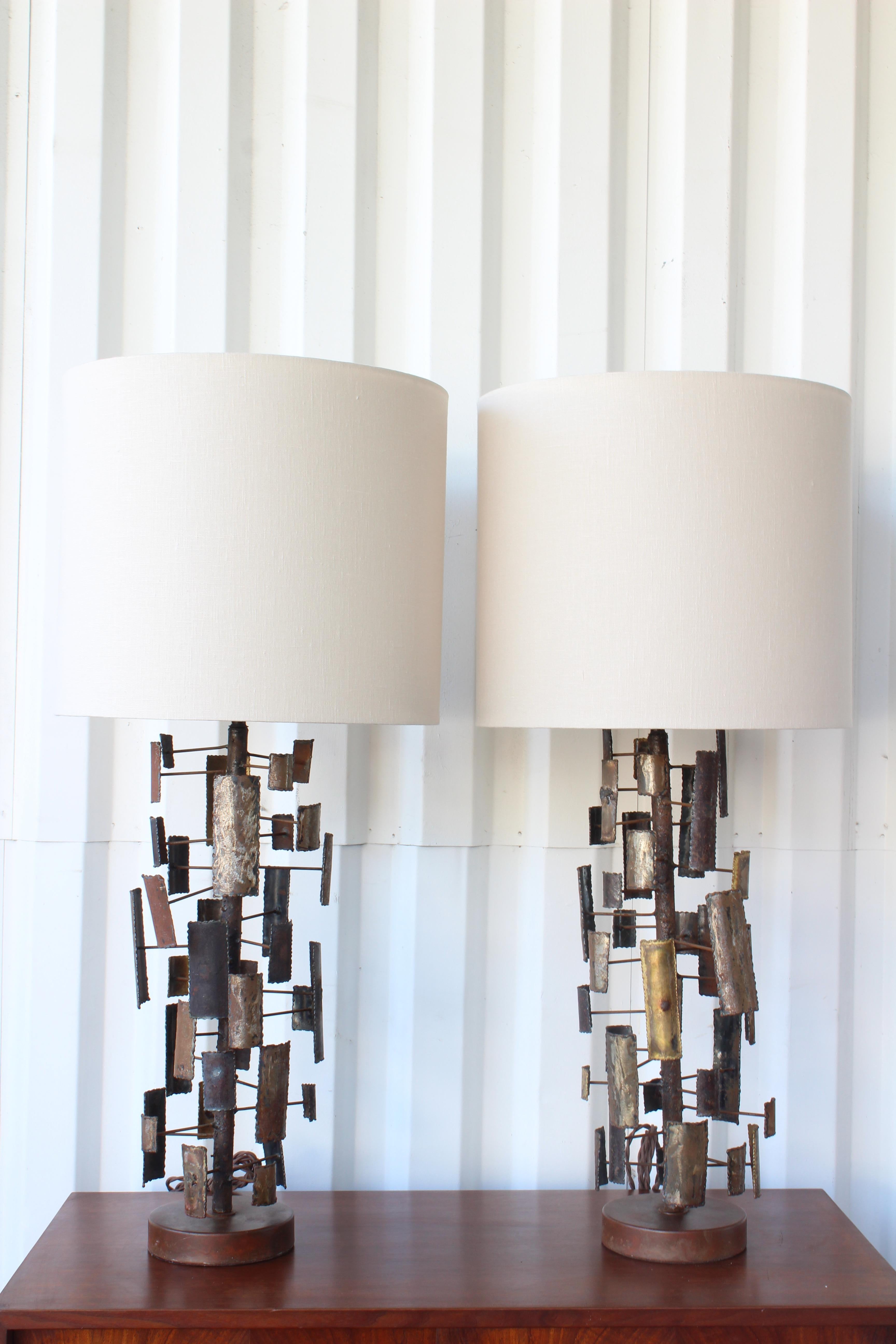 Pair of brutalist torch cut table lamps. Newly rewired with custom made linen shades. Base is 24