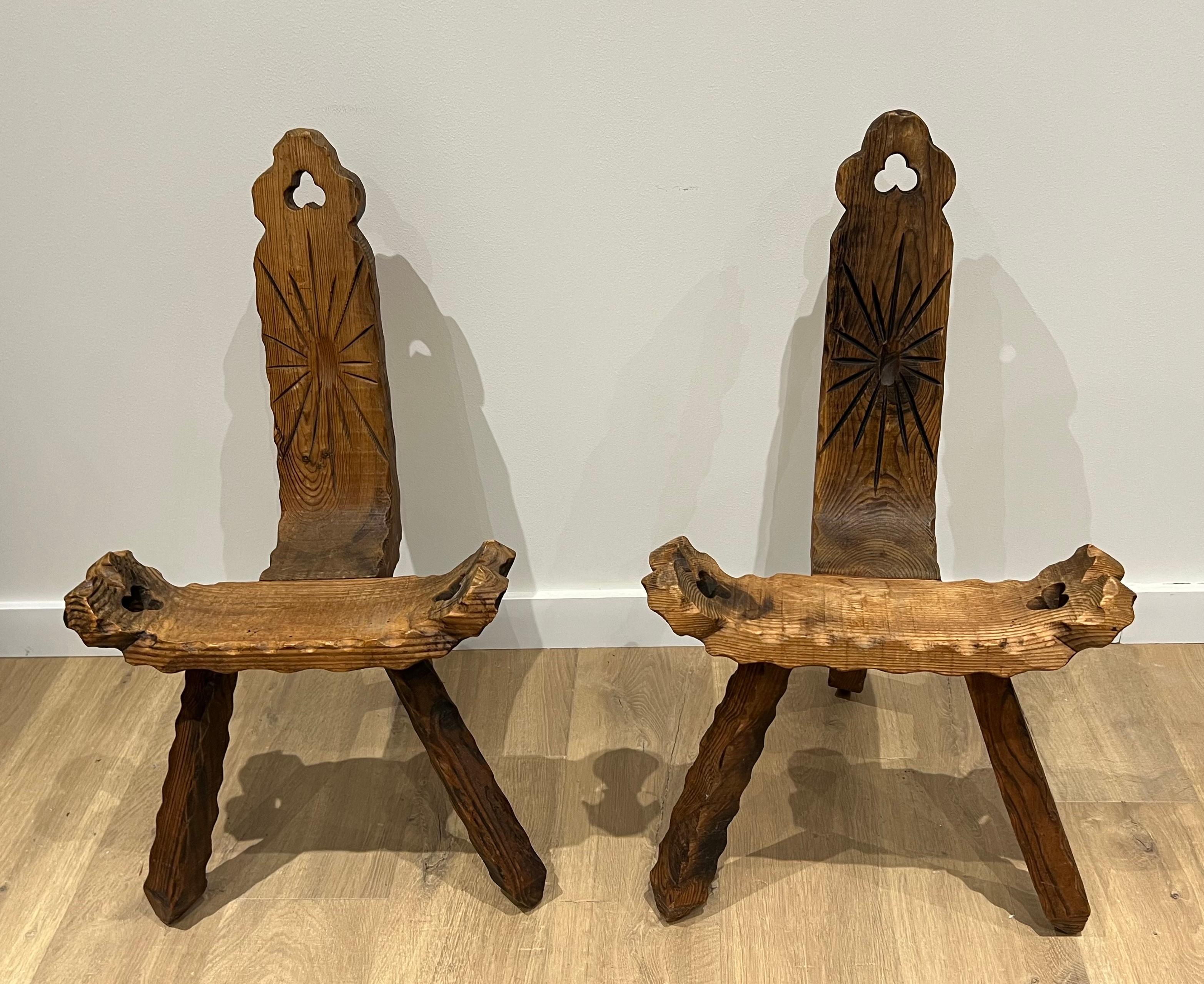 Cette très belle paire de chaises basses tripodes brutalistes est fabriquée en bois sculpté et gaufré. Il s'agit d'un ouvrage français. Circa 1950