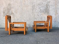 pair of brutalist wood and leather armchairs