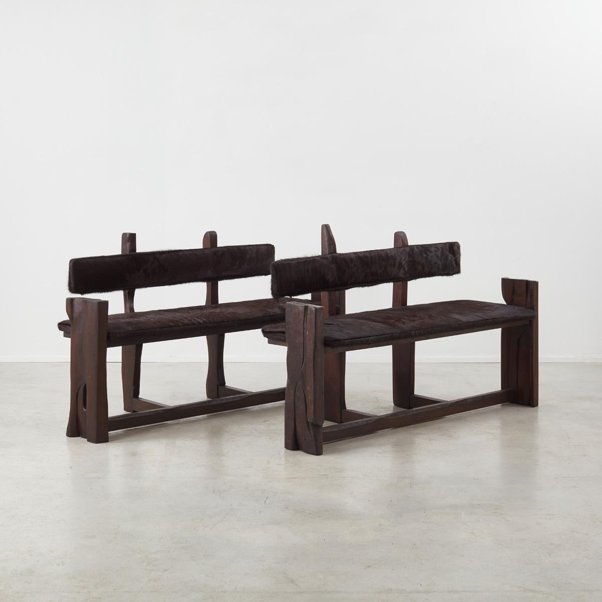 A 1970s French chunky-wood pair of benches (a part of a dining set consisting of a pair of benches and a pair of armchairs/chairs, but sold inidvidually), with a blackened wood structure and a new upholstery in chocolate brown ‘ponyhair’. The
