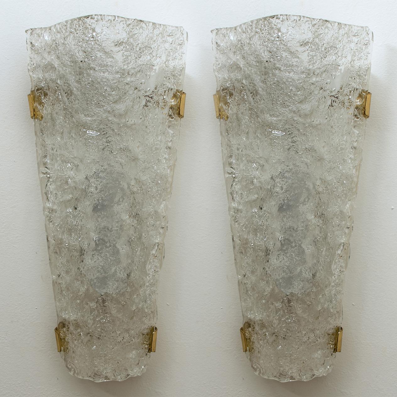 Pair of sconces by Hillebrand. With bubble glass shade, brass details a white backplate and mounting hardware. 

The glass plate is made of tiny glass shards which are molded into the glass during its manufacture giving the piece a heavy ice